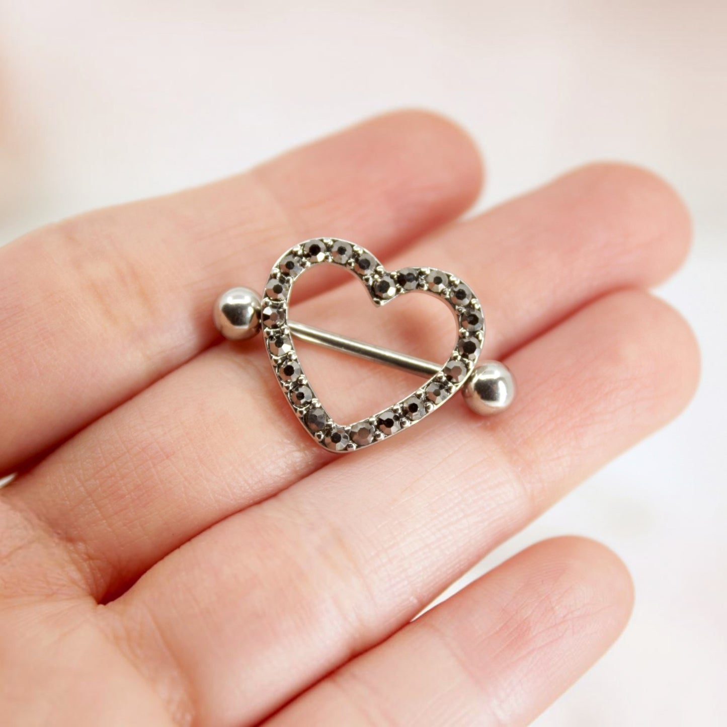 MKBodyJewelry 14G surgical steel nipple barbell featuring a silver heart shield with black paved gemstones.