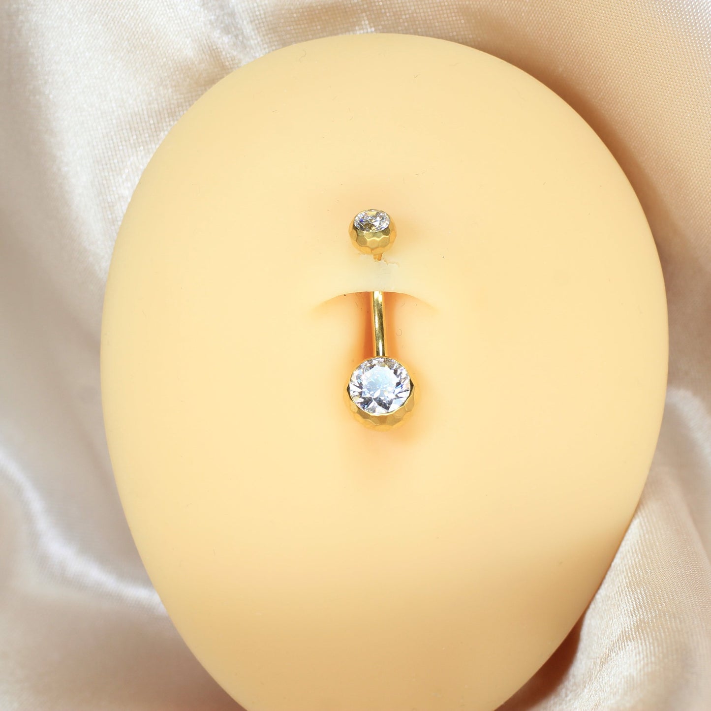 MKBodyJewelry gold titanium belly button ring with a sparkling CZ stone in a honeycomb setting on a mannequin torso.
