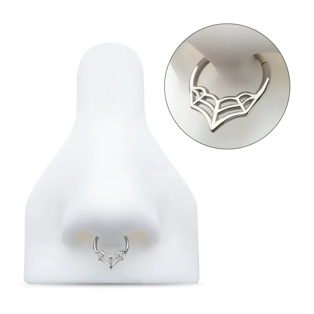MKBodyJewelry 16G silver surgical steel spider web septum clicker ring on a white nose display model