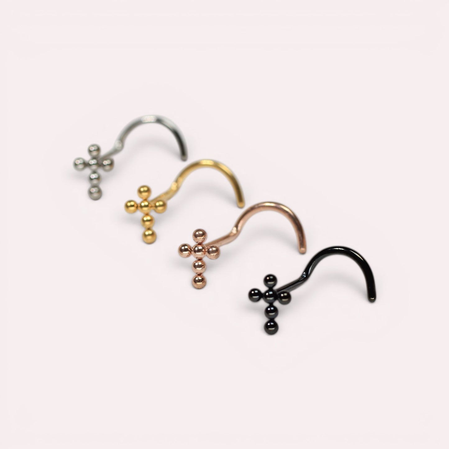 MKBodyJewelry titanium cross nose studs in silver, gold, rose gold, and black with beaded detail and corkscrew posts.