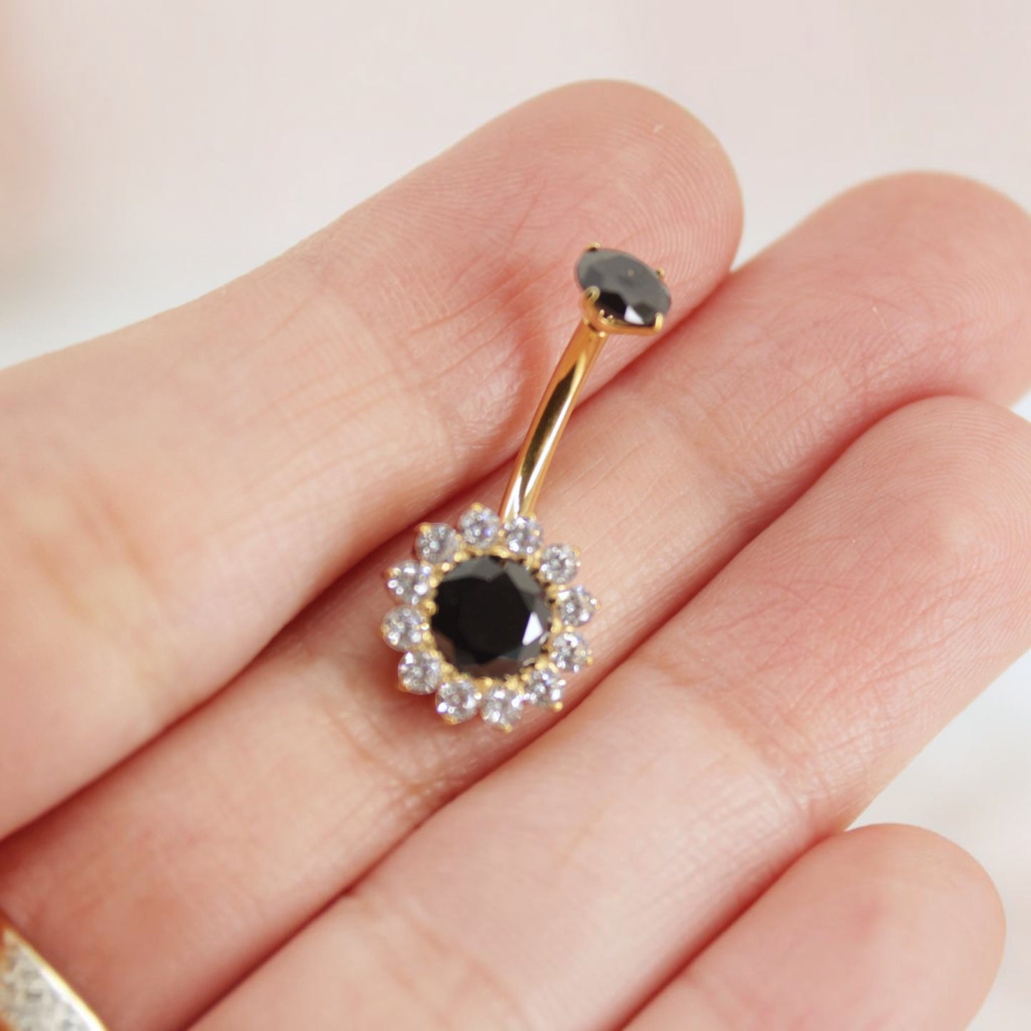 MKBodyJewelry 14g titanium belly button ring featuring a black floral gemstone design with clear crystal accents.