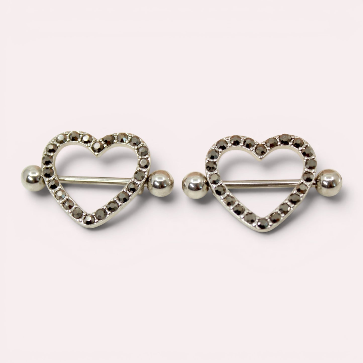 MKBodyJewelry 14G surgical steel nipple barbell set featuring silver heart shields with black paved gemstones.