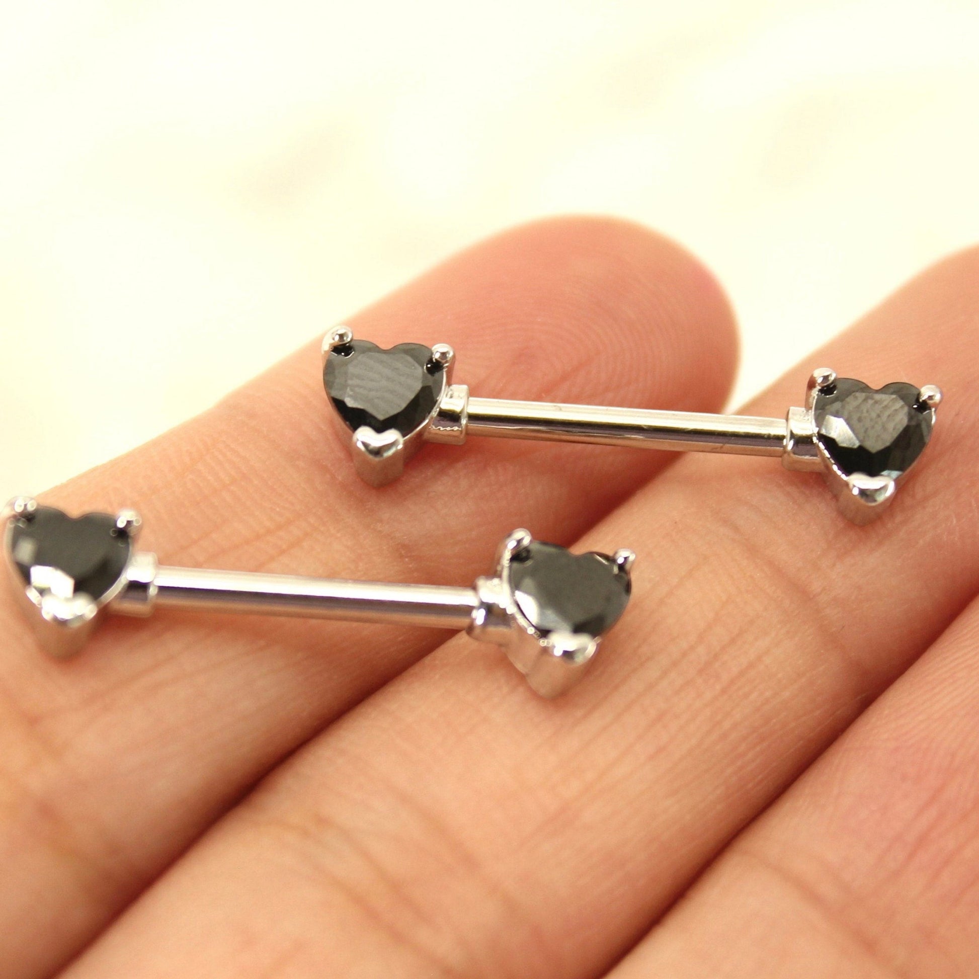 MKBodyJewelry 14g surgical steel nipple barbells featuring black heart-shaped gems, sold as a pair.
