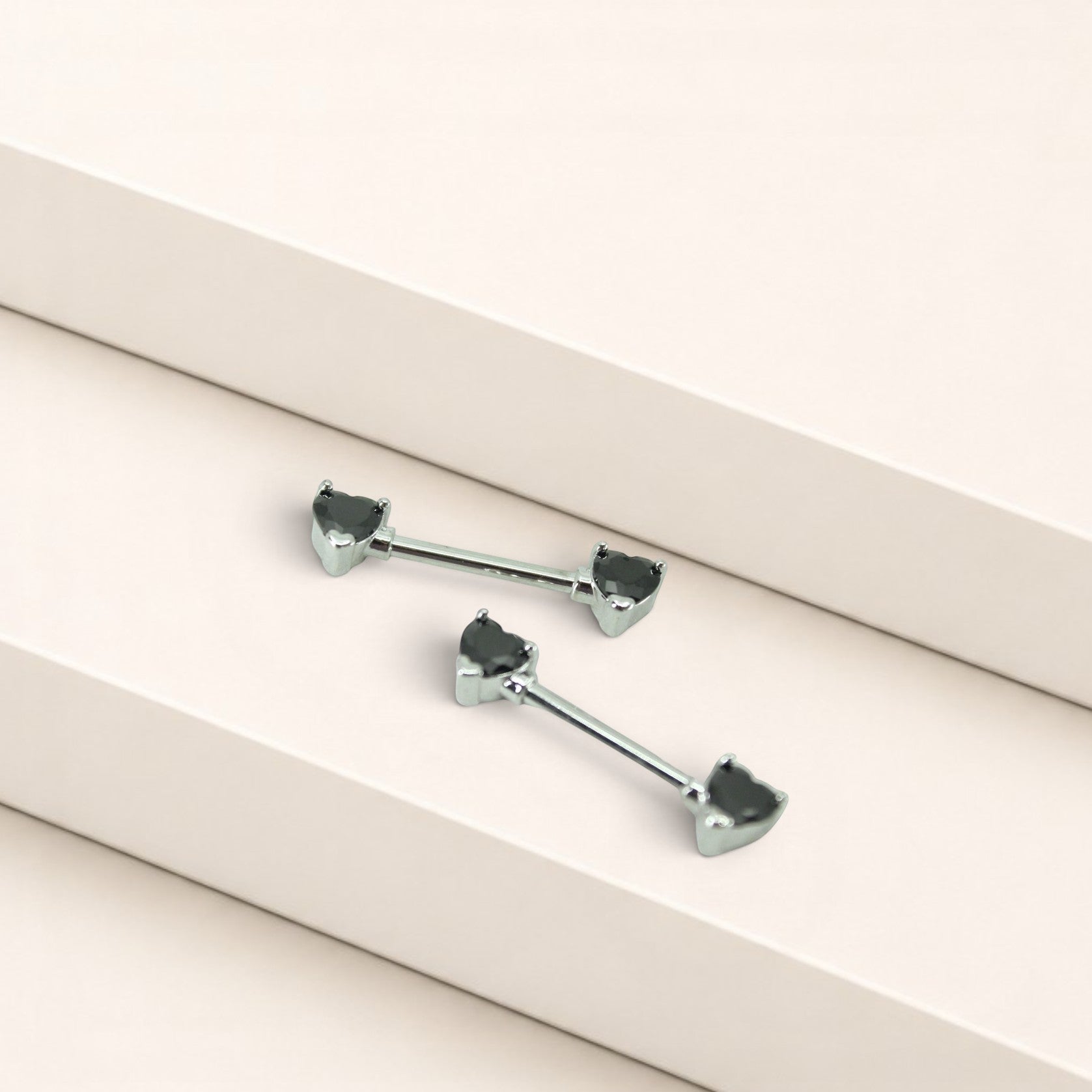 MKBodyJewelry 14g surgical steel nipple barbells featuring black heart-shaped gems, sold as a pair.