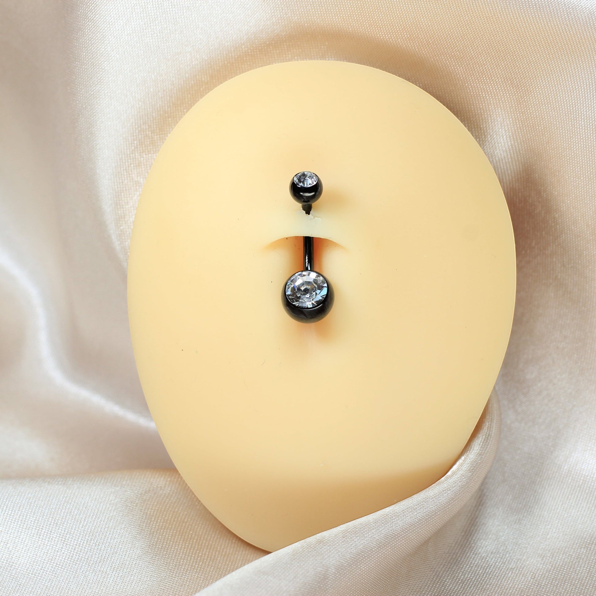 MKBodyJewelry titanium internally threaded belly button ring with black finish and sparkling CZ jewels on a display.