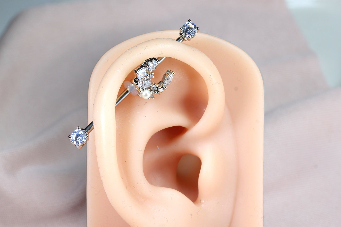 MKBodyJewelry 14G surgical steel industrial barbell with a dainty crescent moon charm adorned with cubic zirconia and a pearl.