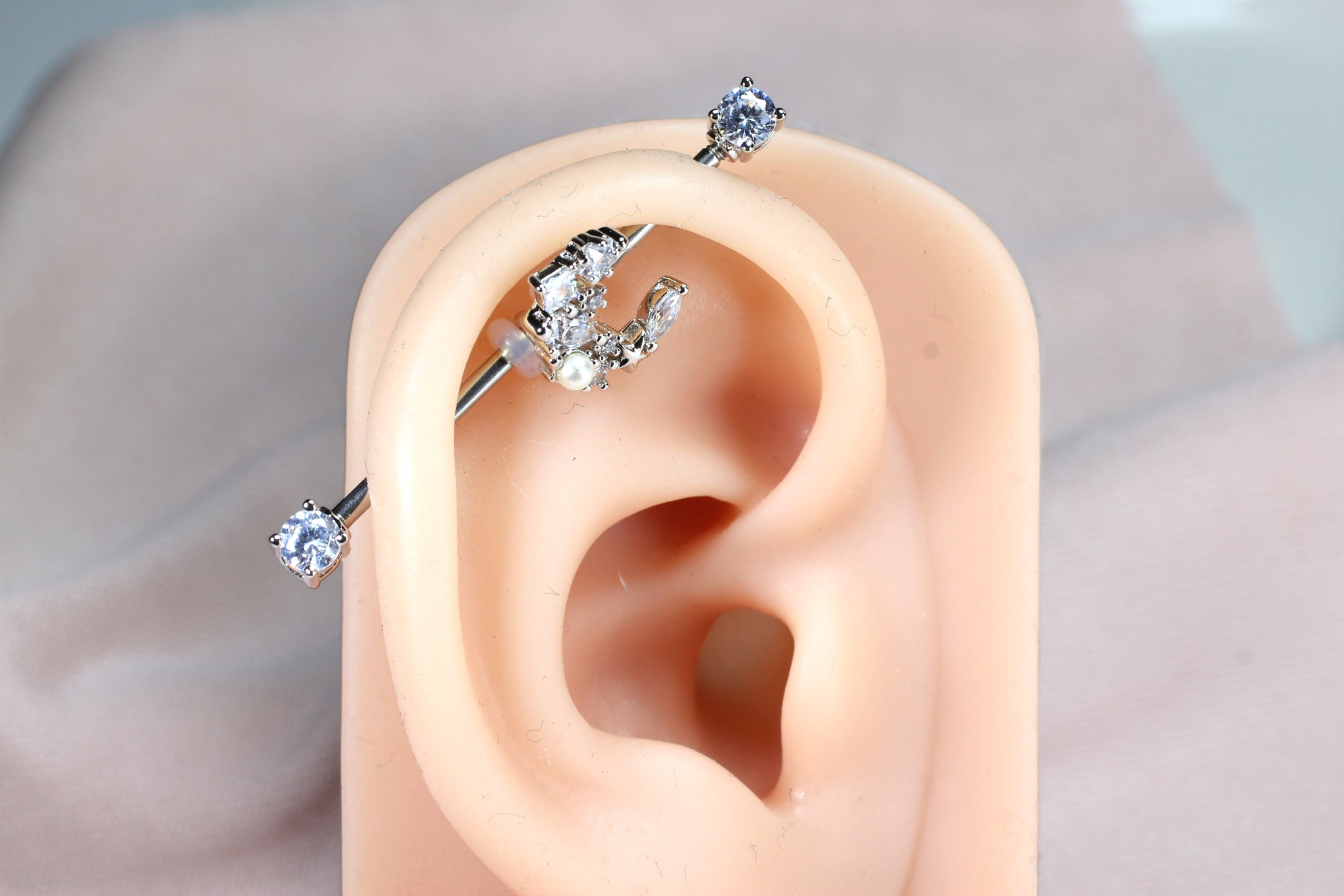 MKBodyJewelry 14G surgical steel industrial barbell with a dainty crescent moon charm adorned with cubic zirconia and a pearl.