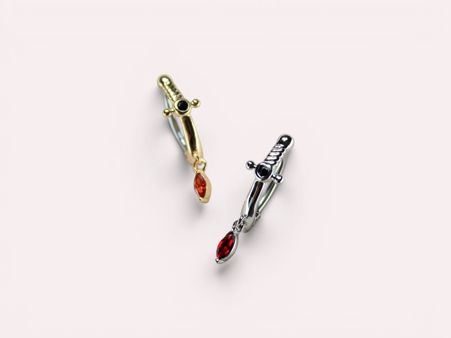 MKBodyJewelry gold and silver dagger belly button rings with dangling red CZ stones. 14G, 10mm stainless steel clicker.