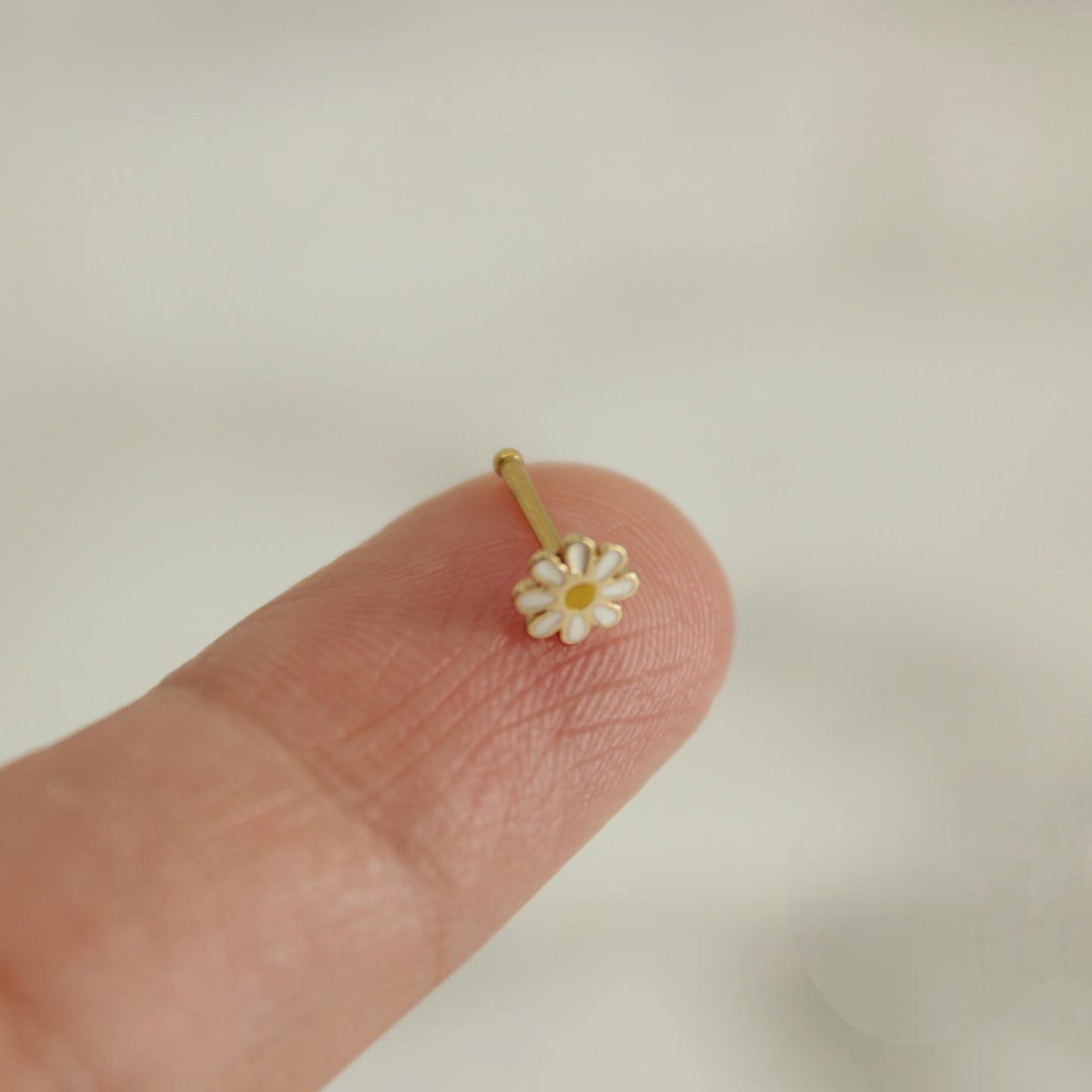 MKBodyJewelry 20g surgical steel nose bone stud featuring a cute white and yellow daisy flower design.