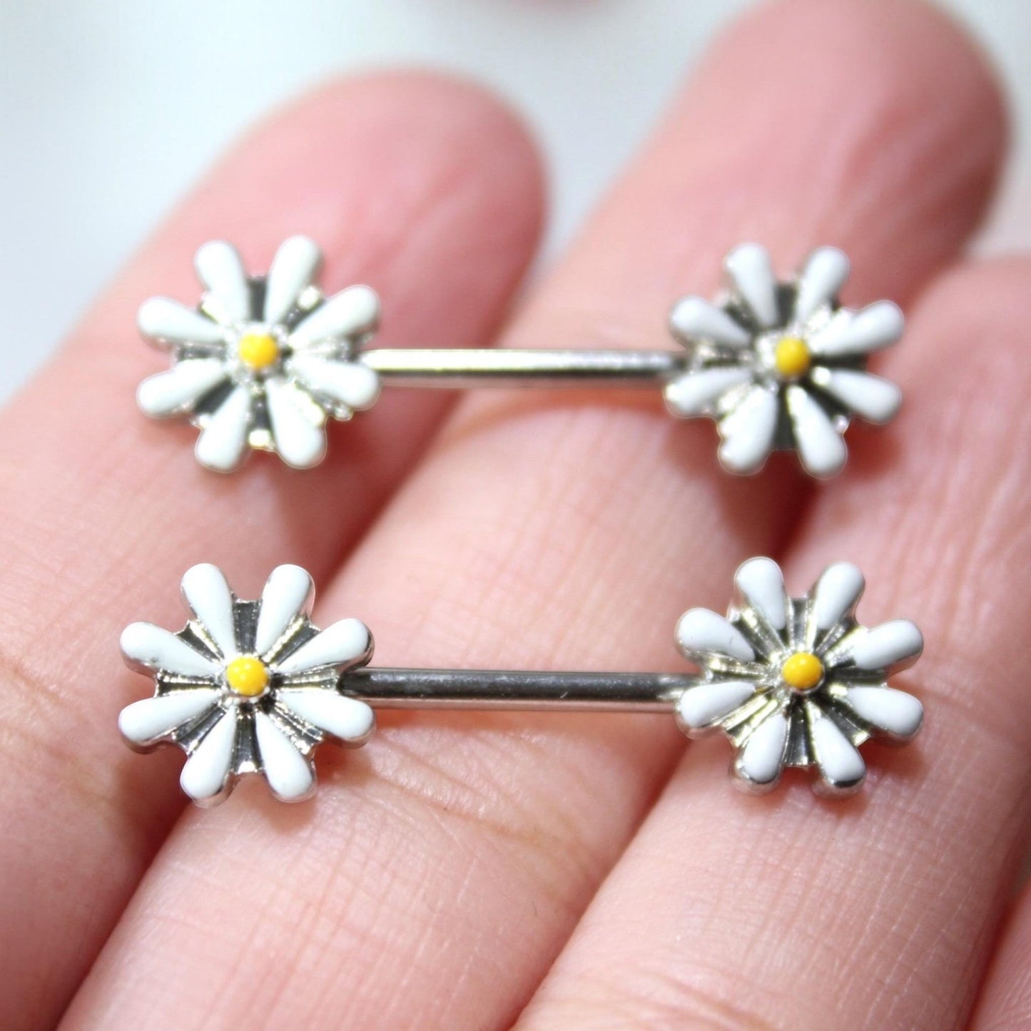 MKBodyJewelry 14G surgical steel nipple barbell set featuring white and yellow daisy flower ends.