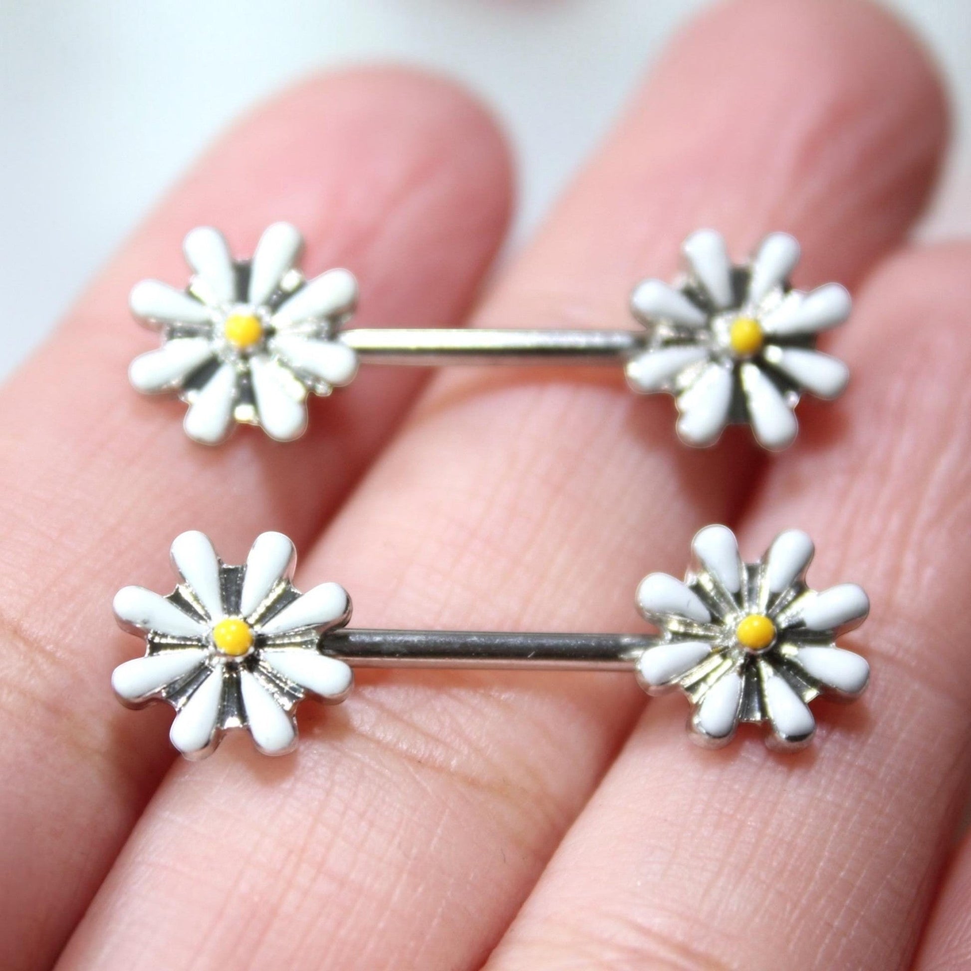 MKBodyJewelry 14G surgical steel nipple barbell set featuring white and yellow daisy flower ends.