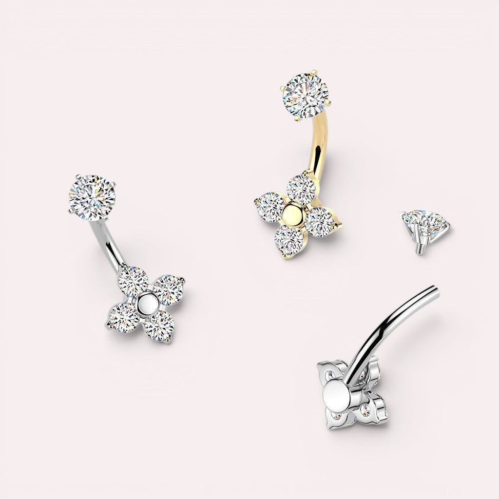 MKBodyJewelry silver and gold belly button rings with four-petal flower design adorned with cubic zirconia.