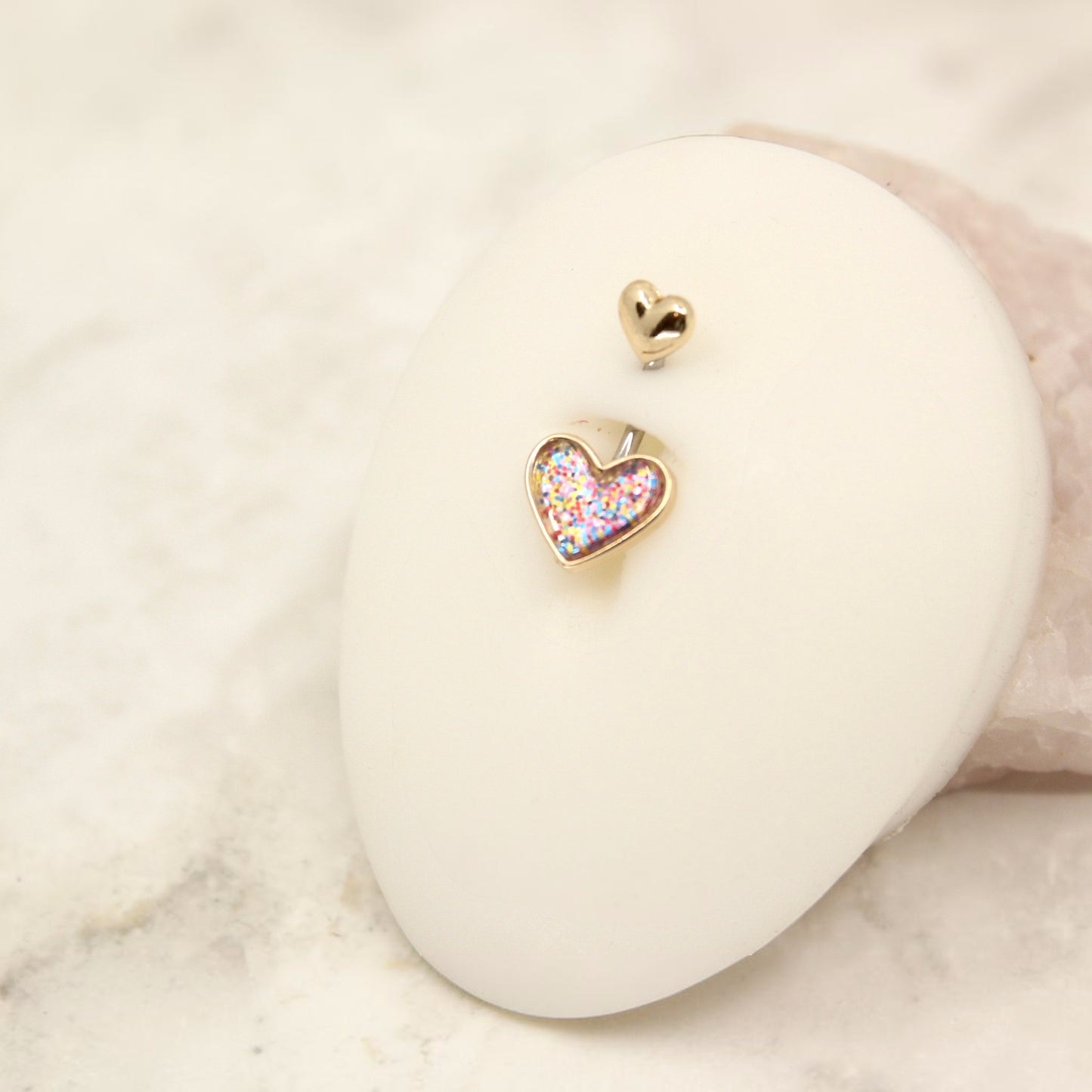 MKBodyJewelry 14G surgical steel belly button ring featuring a gold-tone heart charm with colorful glitter resin.