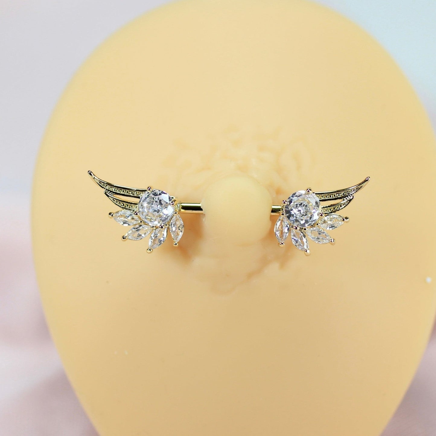MKBodyJewelry 14g gold nipple barbell with clear crystal angel wings. Surgical steel and titanium.
