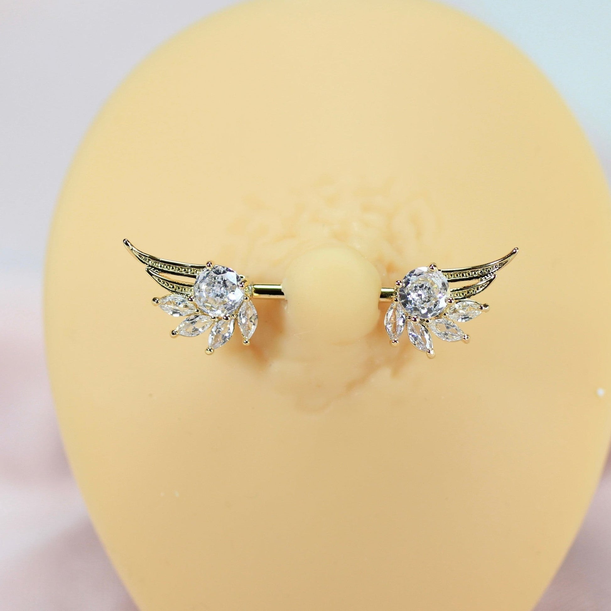 MKBodyJewelry 14g gold nipple barbell with clear crystal angel wings. Surgical steel and titanium.