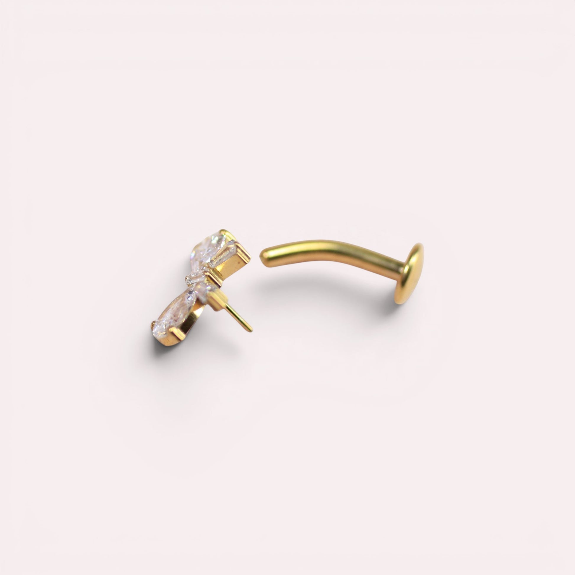 MKBodyJewelry dainty gold titanium threadless bow belly ring with clear cubic zirconia stones.