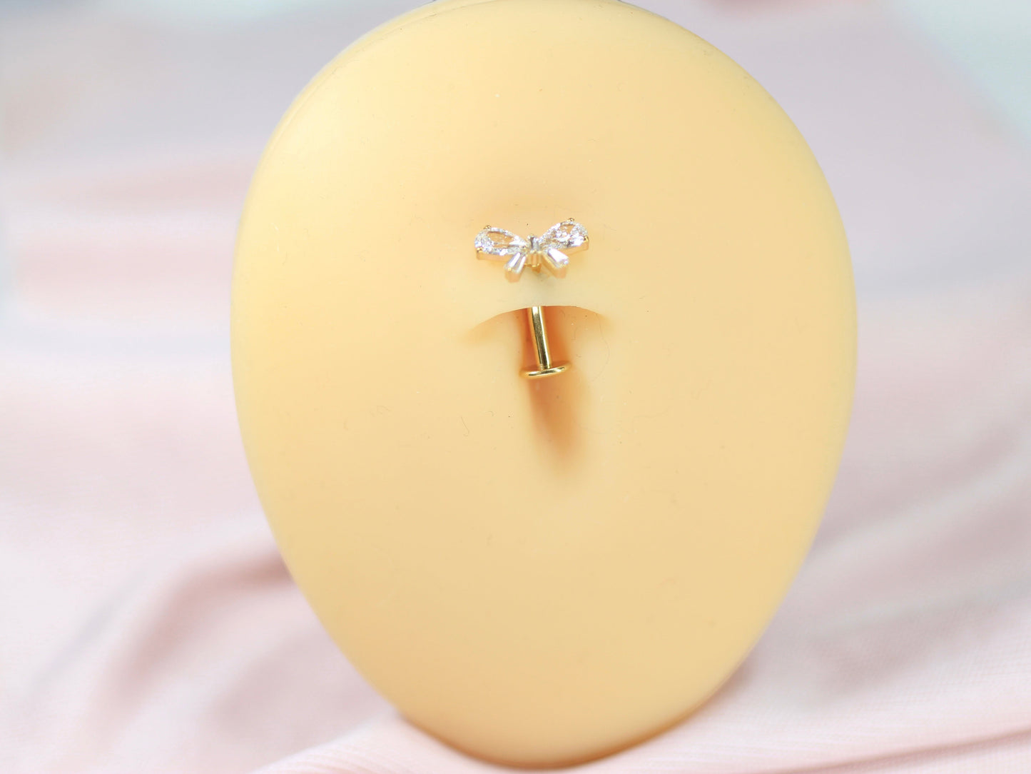MKBodyJewelry dainty titanium gold bow belly ring with clear cubic zirconia accents. 14G, 10mm barbell.