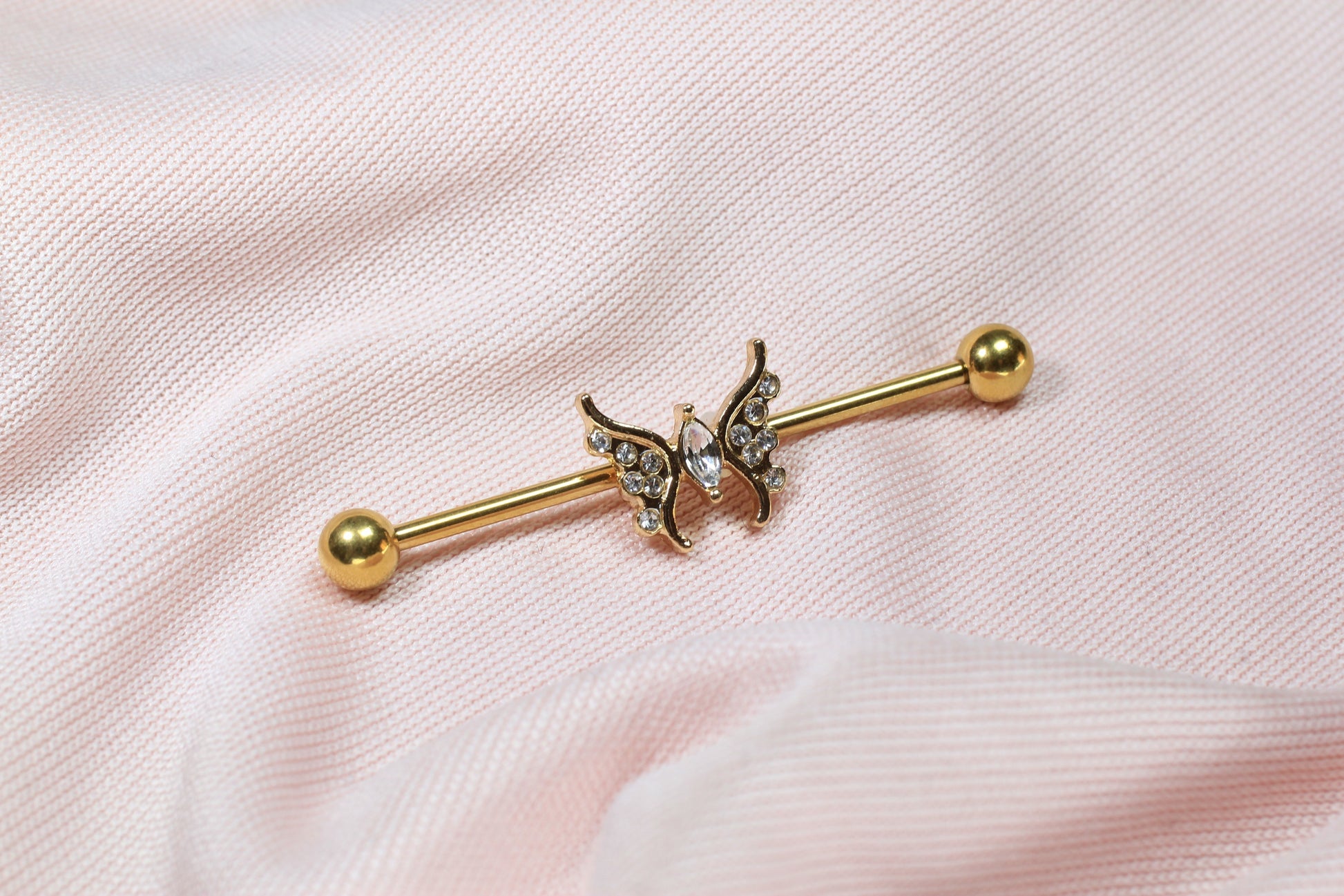 MKBodyJewelry 14G gold industrial barbell with a dainty CZ butterfly charm, 35mm surgical steel scaffold bar.