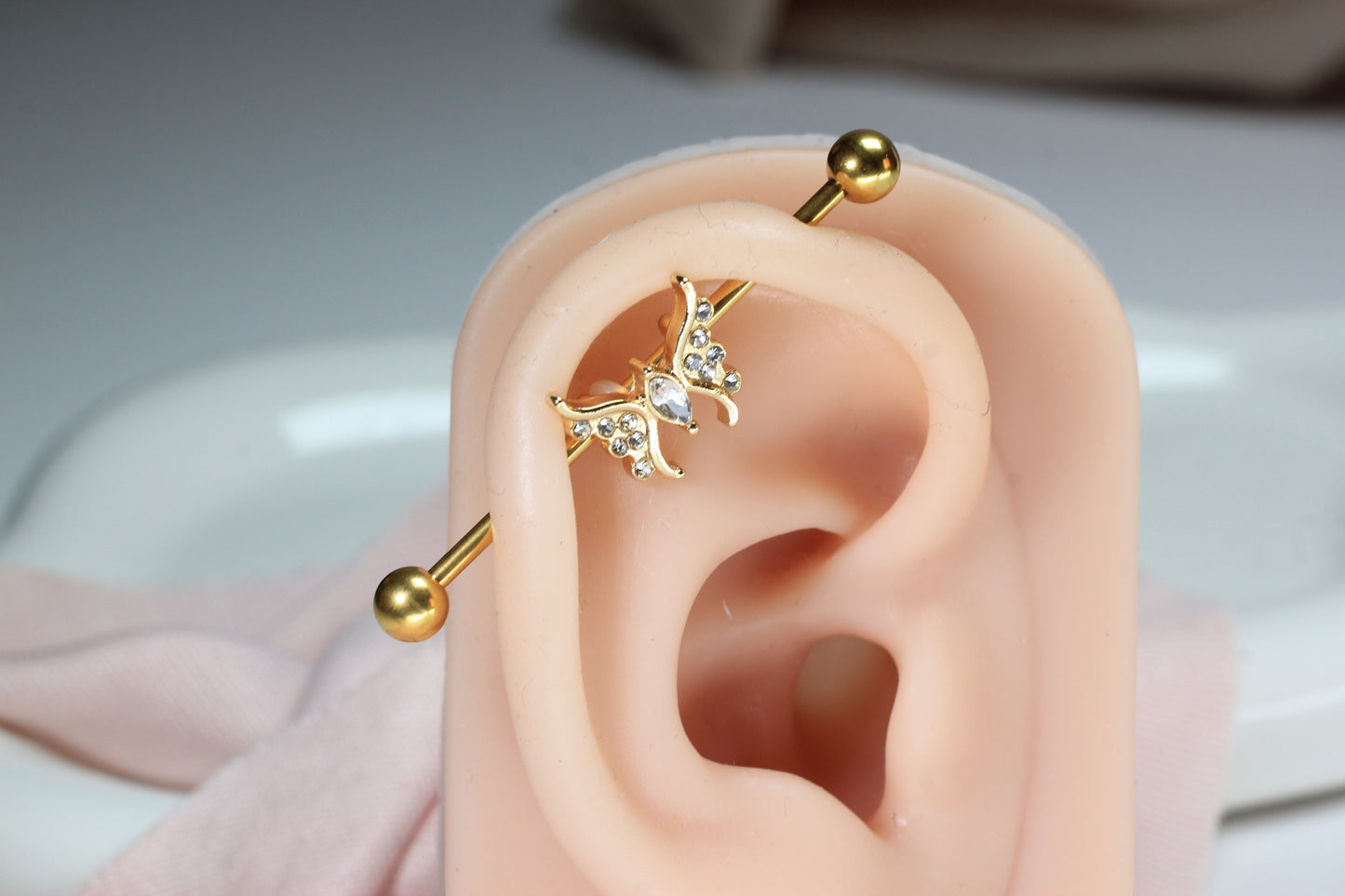 MKBodyJewelry 14G gold surgical steel industrial barbell with a dainty CZ butterfly charm, 35mm length.