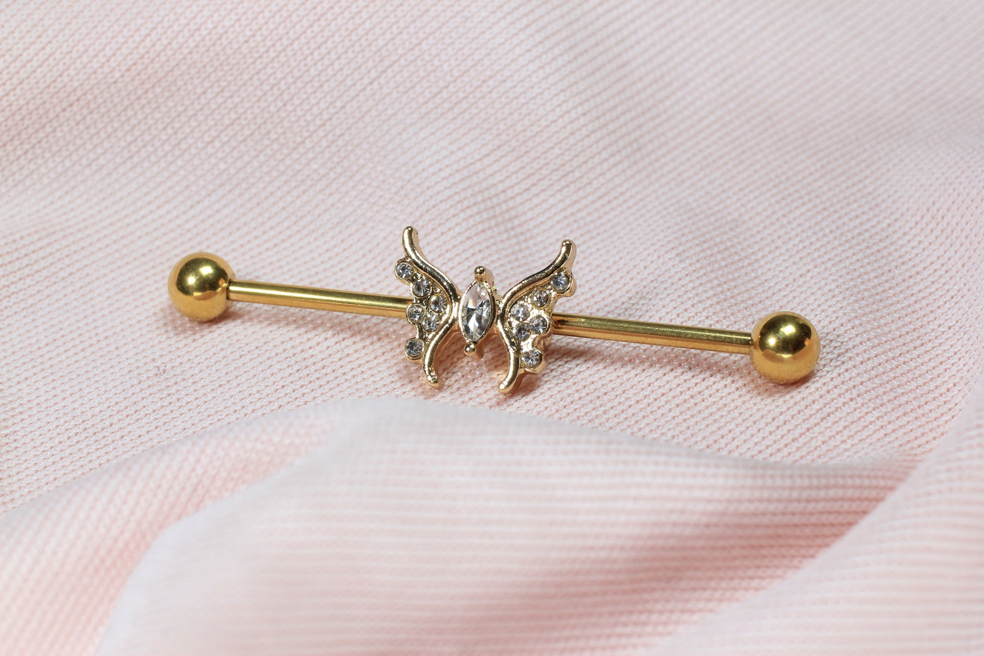 MKBodyJewelry gold 14G surgical steel industrial barbell with a dainty CZ butterfly charm, 35mm length.