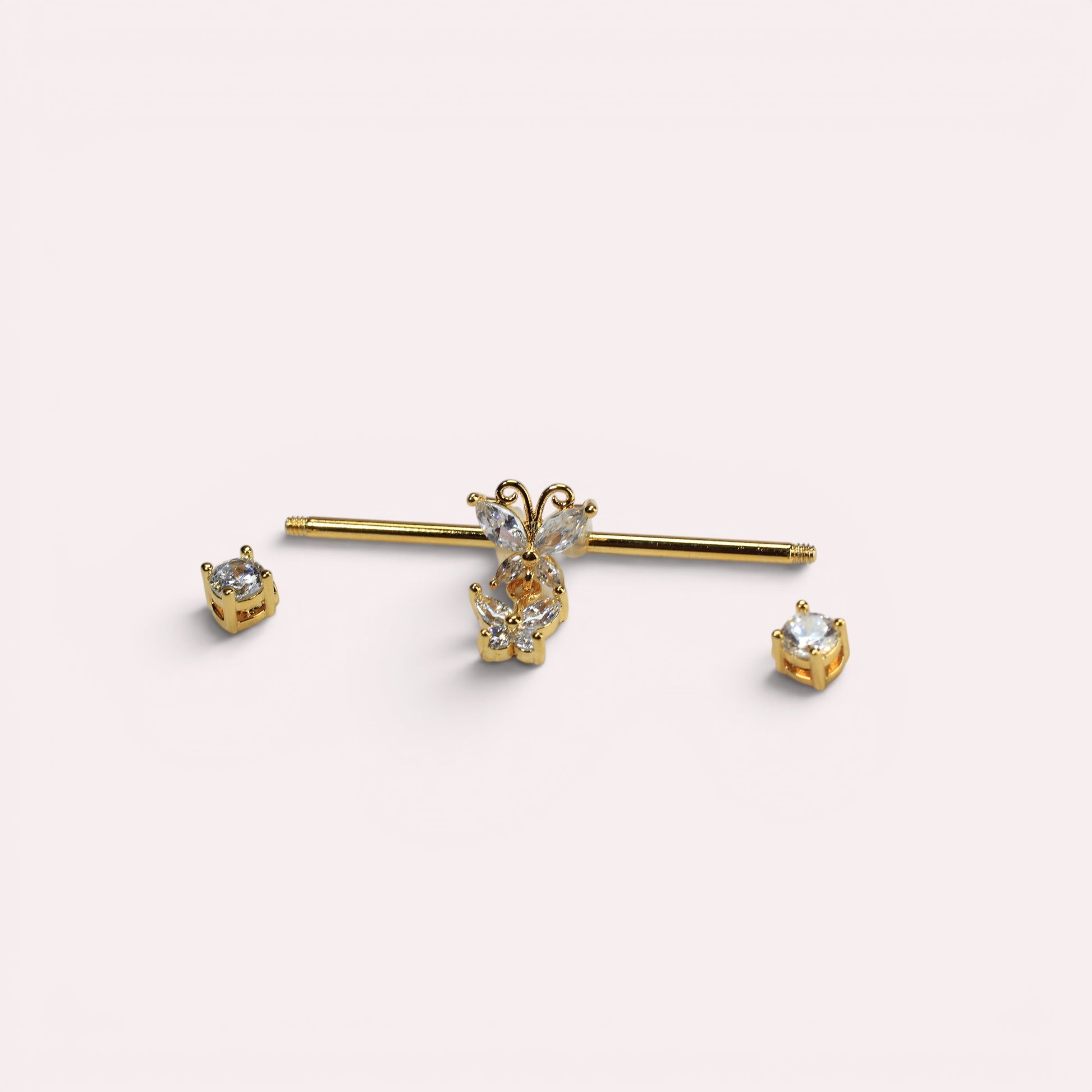 MKBodyJewelry gold surgical steel 14G industrial barbell with dangling butterfly charm and clear cubic zirconia ends.