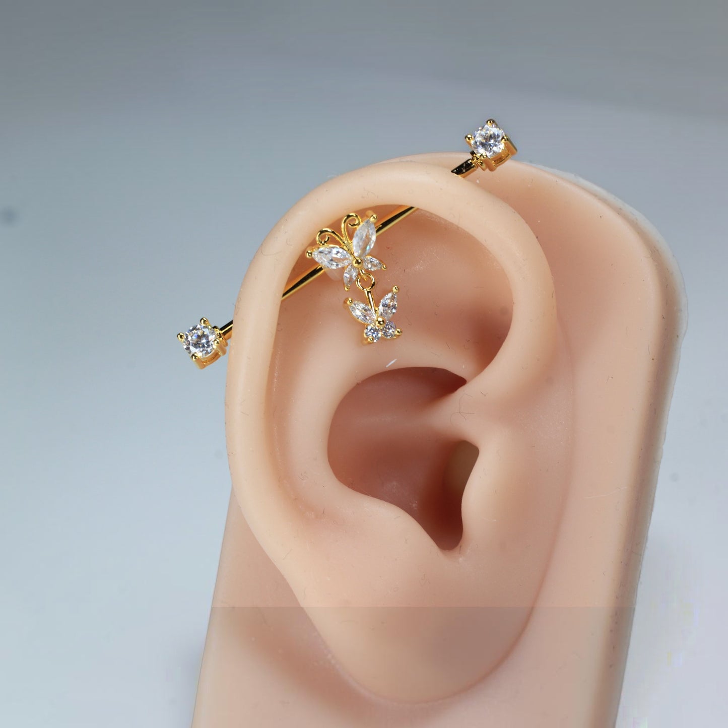 MKBodyJewelry gold surgical steel industrial barbell with dangling butterfly charms and clear cubic zirconia.