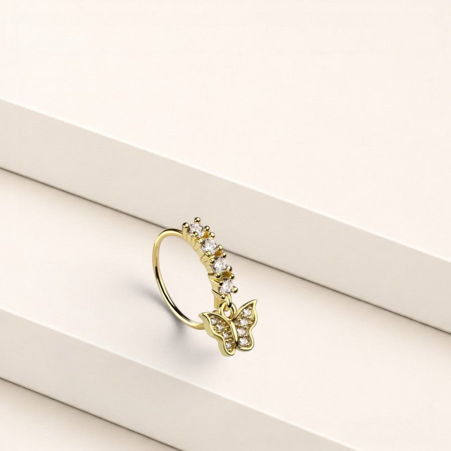MKBodyJewelry gold surgical steel nose hoop ring featuring a dangling butterfly charm with clear crystal accents.