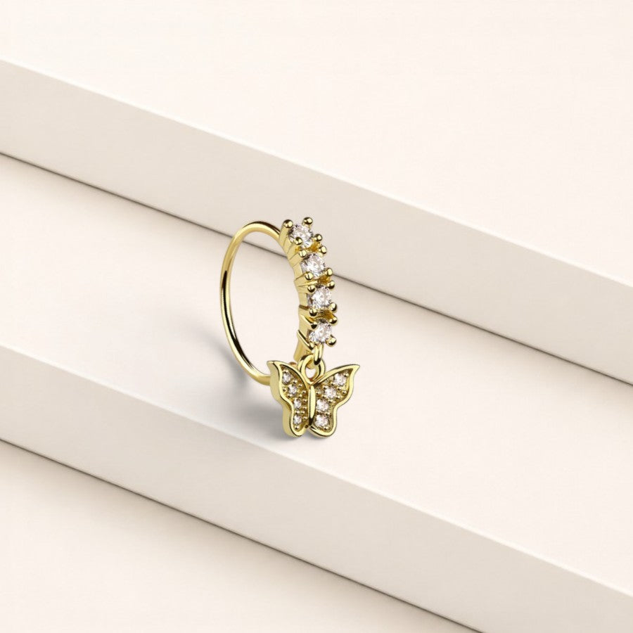 MKBodyJewelry gold surgical steel nose hoop ring featuring a dangling butterfly charm with clear crystal gems.