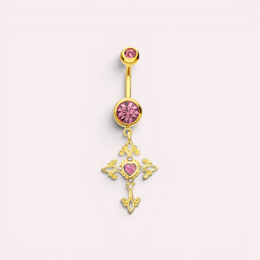 MKBodyJewelry gold-tone surgical steel belly ring featuring a dangling cross with hot pink gems and filigree detail.