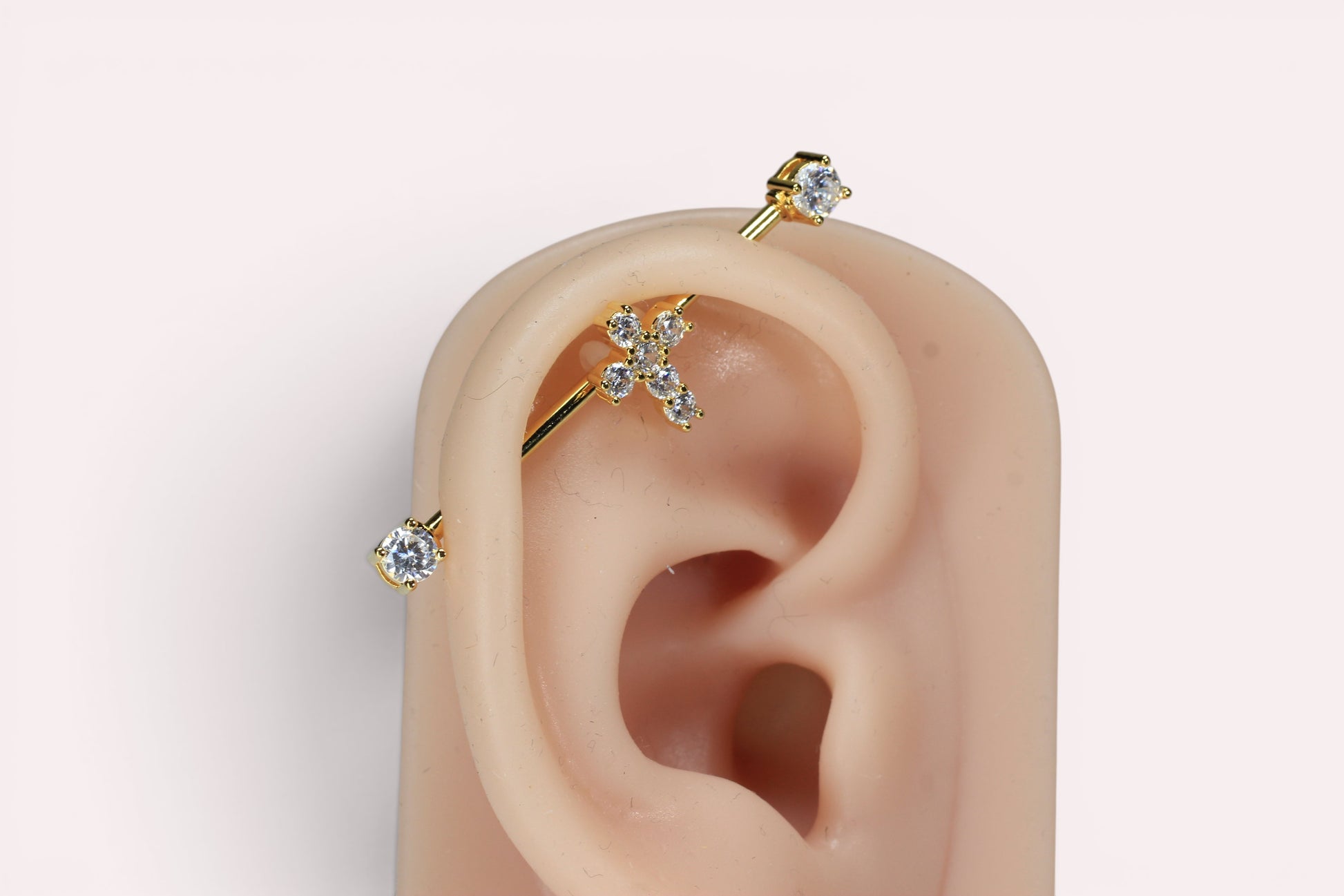 MKBodyJewelry gold 14G surgical steel industrial barbell with a sparkling cross charm and clear cubic zirconia ends.