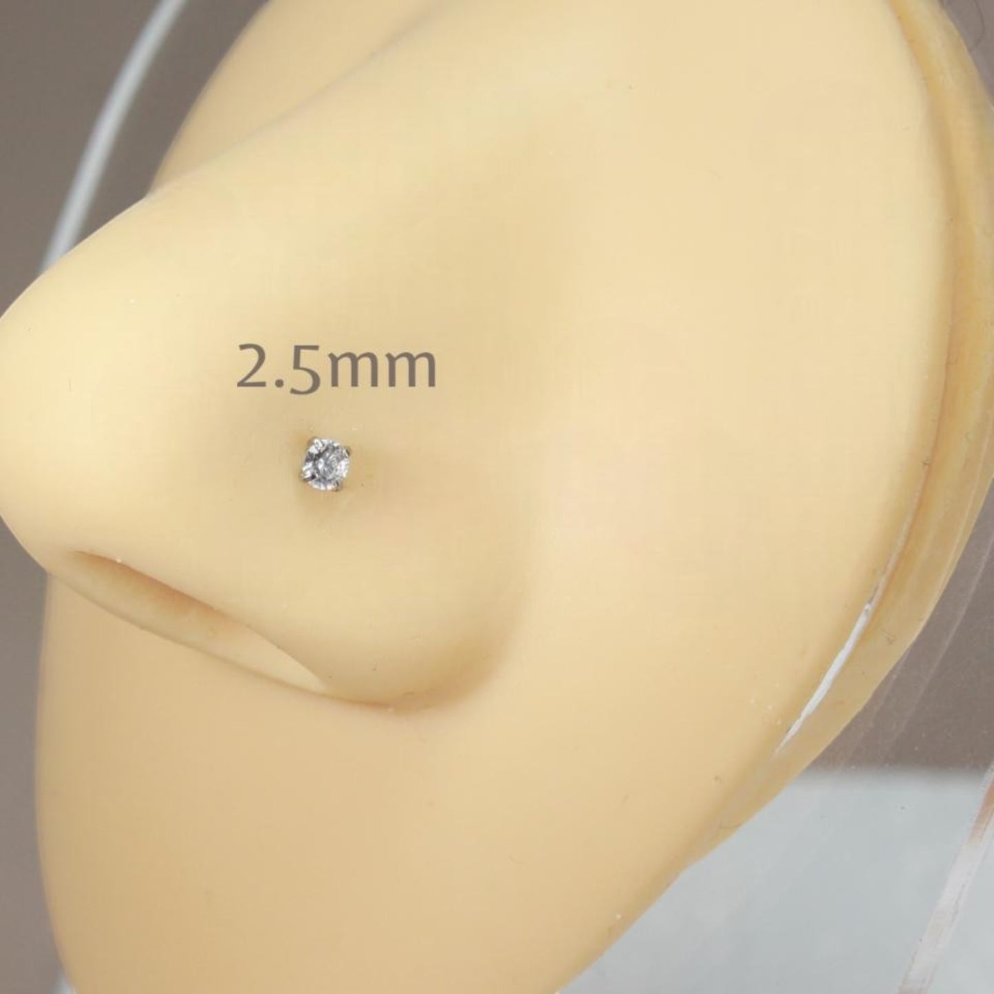 MKBodyJewelry 2.5mm round cut cubic zirconia nose stud in a gold-tone four-prong setting on a mannequin nose