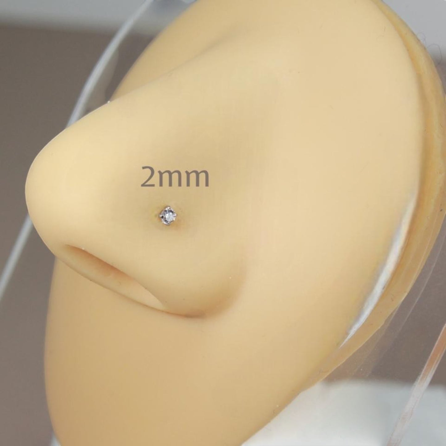 MKBodyJewelry 2mm round cubic zirconia nose stud in a gold-tone four-prong setting on a mannequin nose