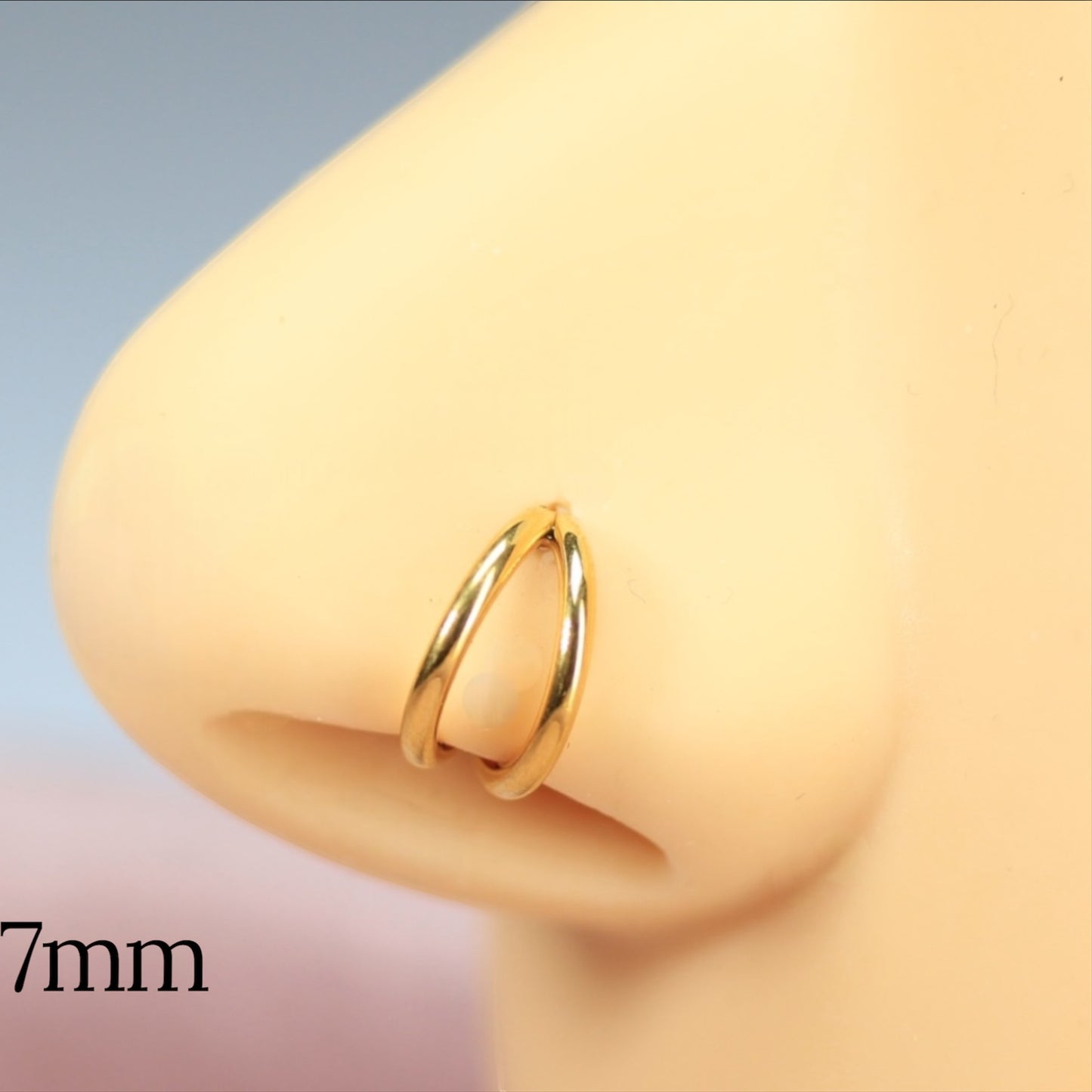 MKBodyJewelry 20g gold double line titanium nose clicker ring on a mannequin nose for a minimalist snug fit.