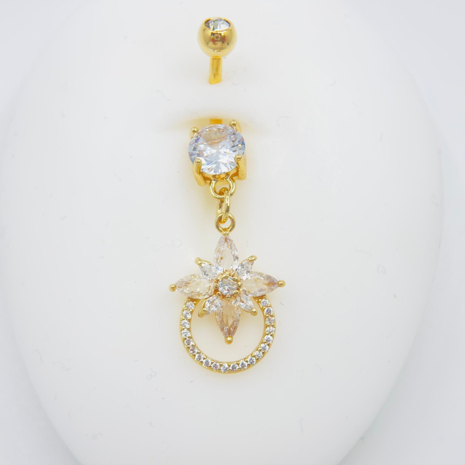 MKBodyJewelry 14g gold surgical steel belly button ring featuring a dangling floral charm with sparkling CZ stones.