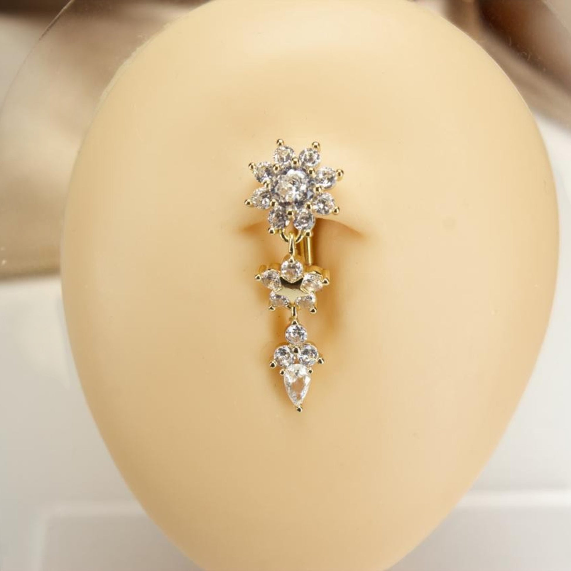 MKBodyJewelry gold-tone dangling belly button ring with floral, star, and teardrop cubic zirconia charms.