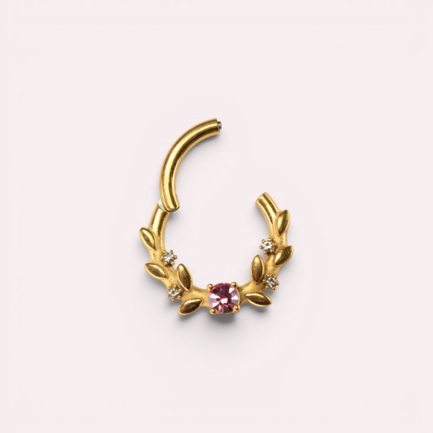 MKBodyJewelry gold surgical steel septum clicker ring with a pink gem and floral leaf design on a light background.