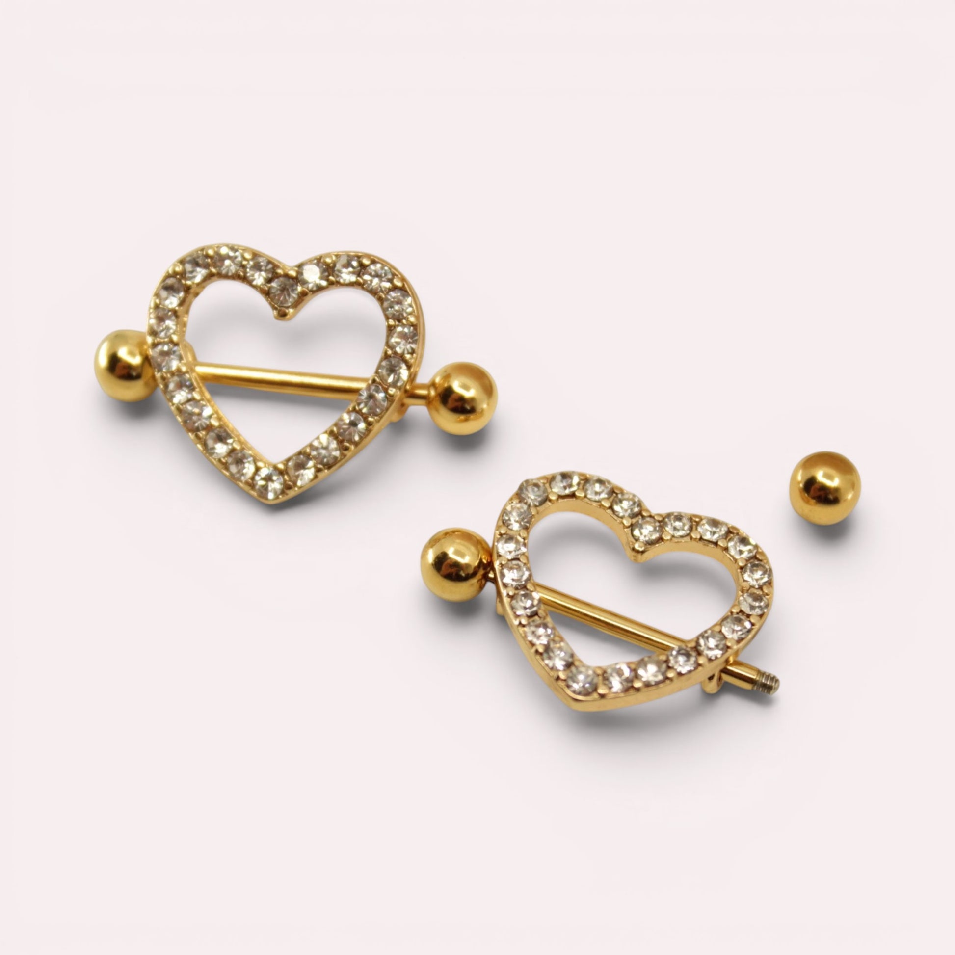 MKBodyJewelry gold heart nipple barbells with sparkling pave gemstones, crafted from surgical steel.