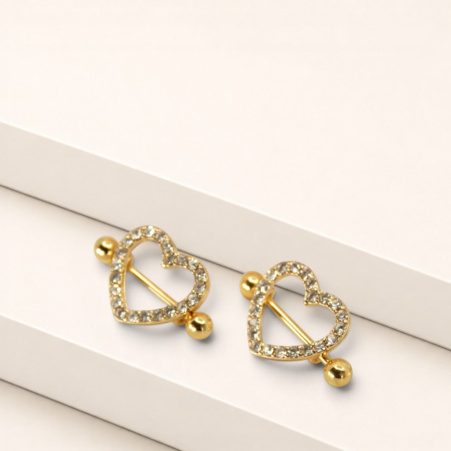 MKBodyJewelry gold heart nipple barbells with sparkling pave gemstones, crafted from surgical steel, sold as a pair.