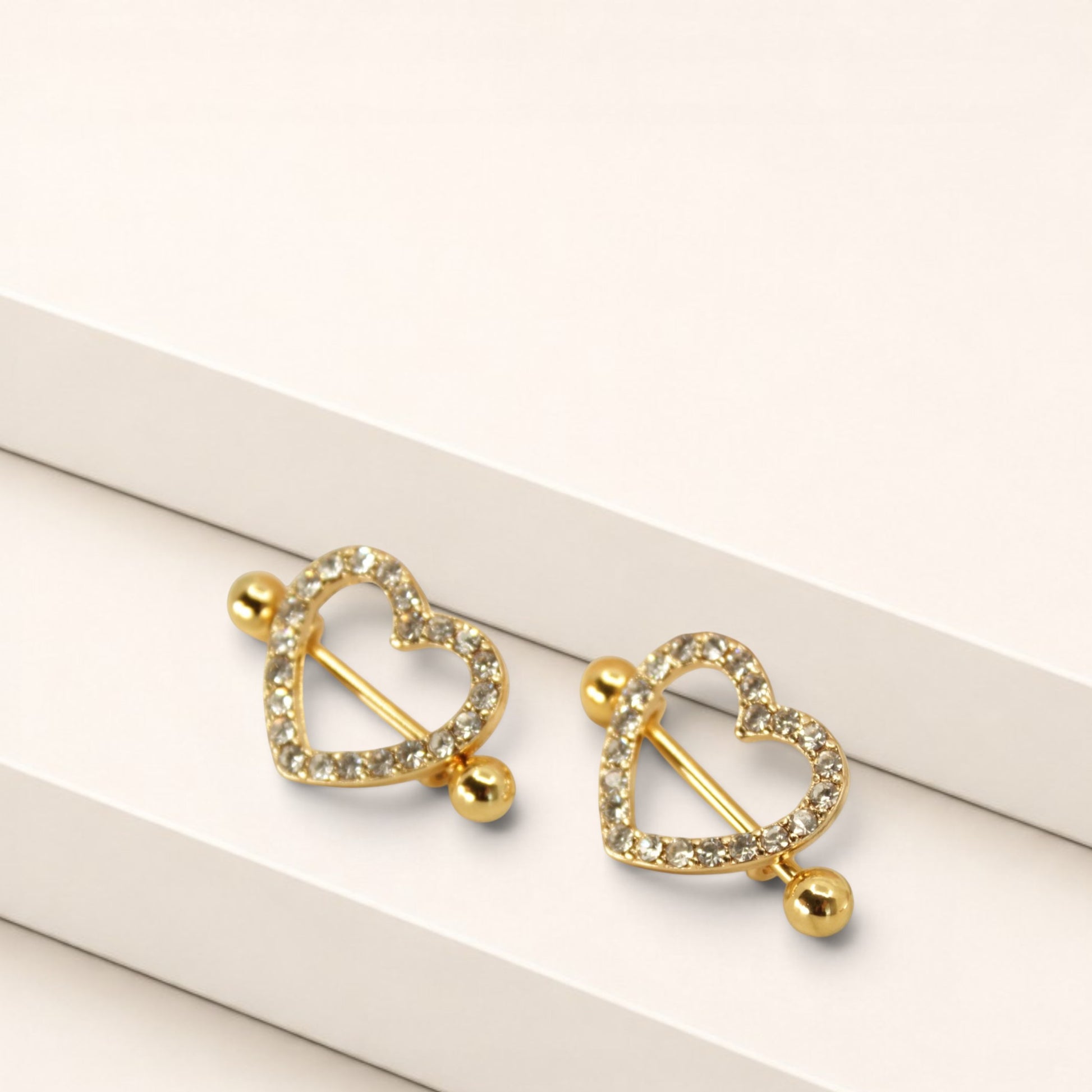 MKBodyJewelry gold heart nipple barbells with sparkling pave gemstones, crafted from surgical steel, sold as a pair.