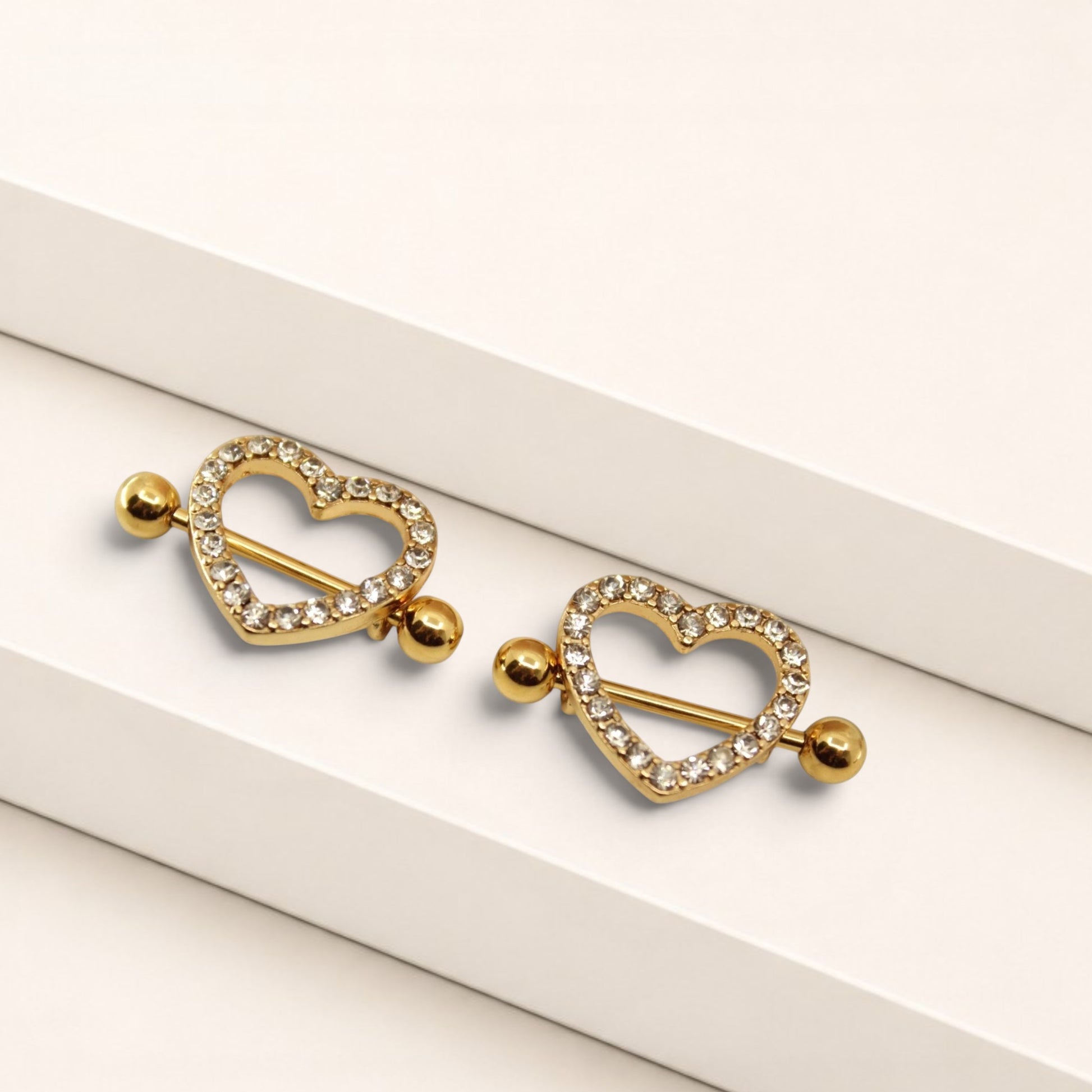 MKBodyJewelry gold heart nipple barbells with sparkling pave gemstones, crafted from surgical steel.