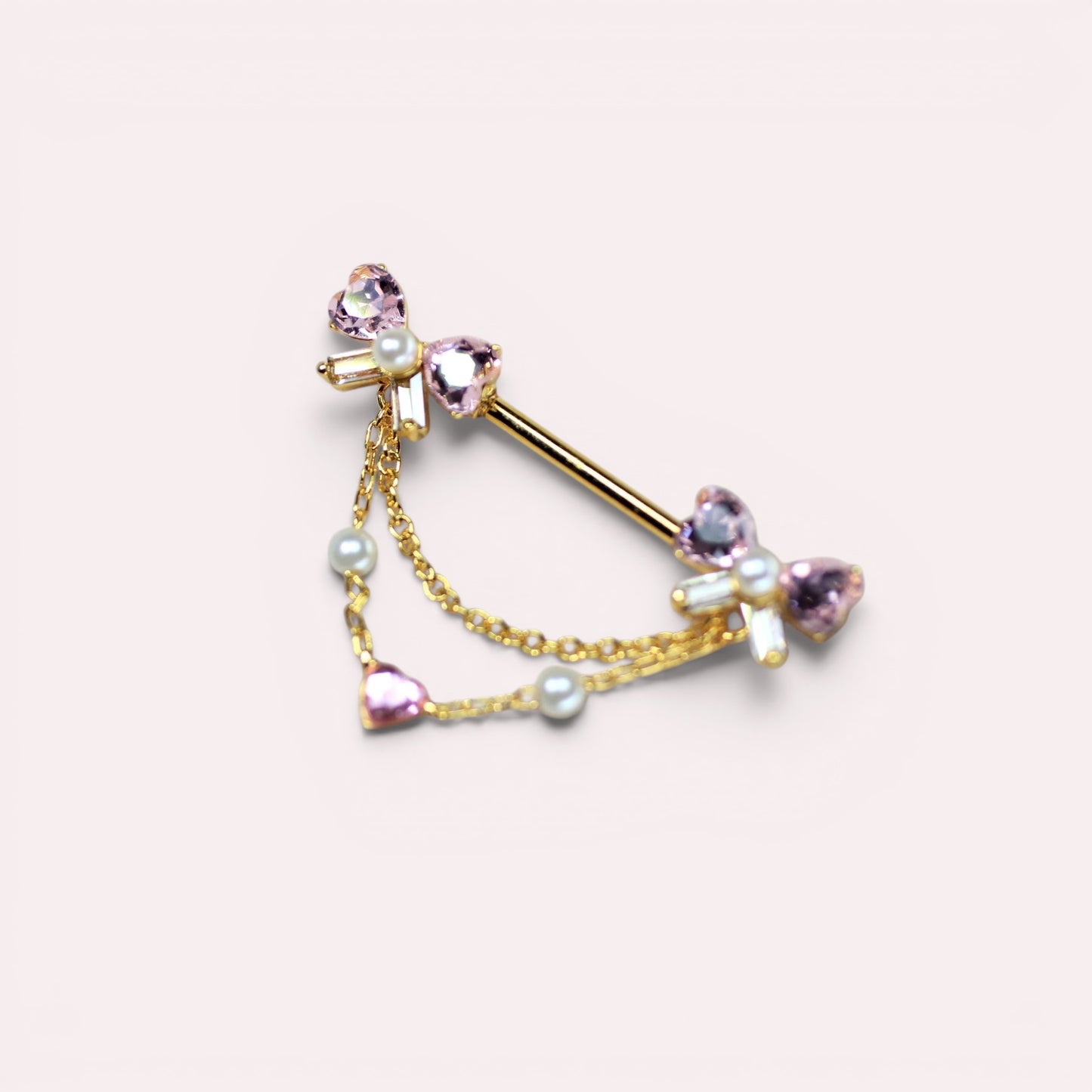 MKBodyJewelry gold 14g nipple barbell with pink bow heart charms, baguette crystals, and pearl accents. Surgical steel.
