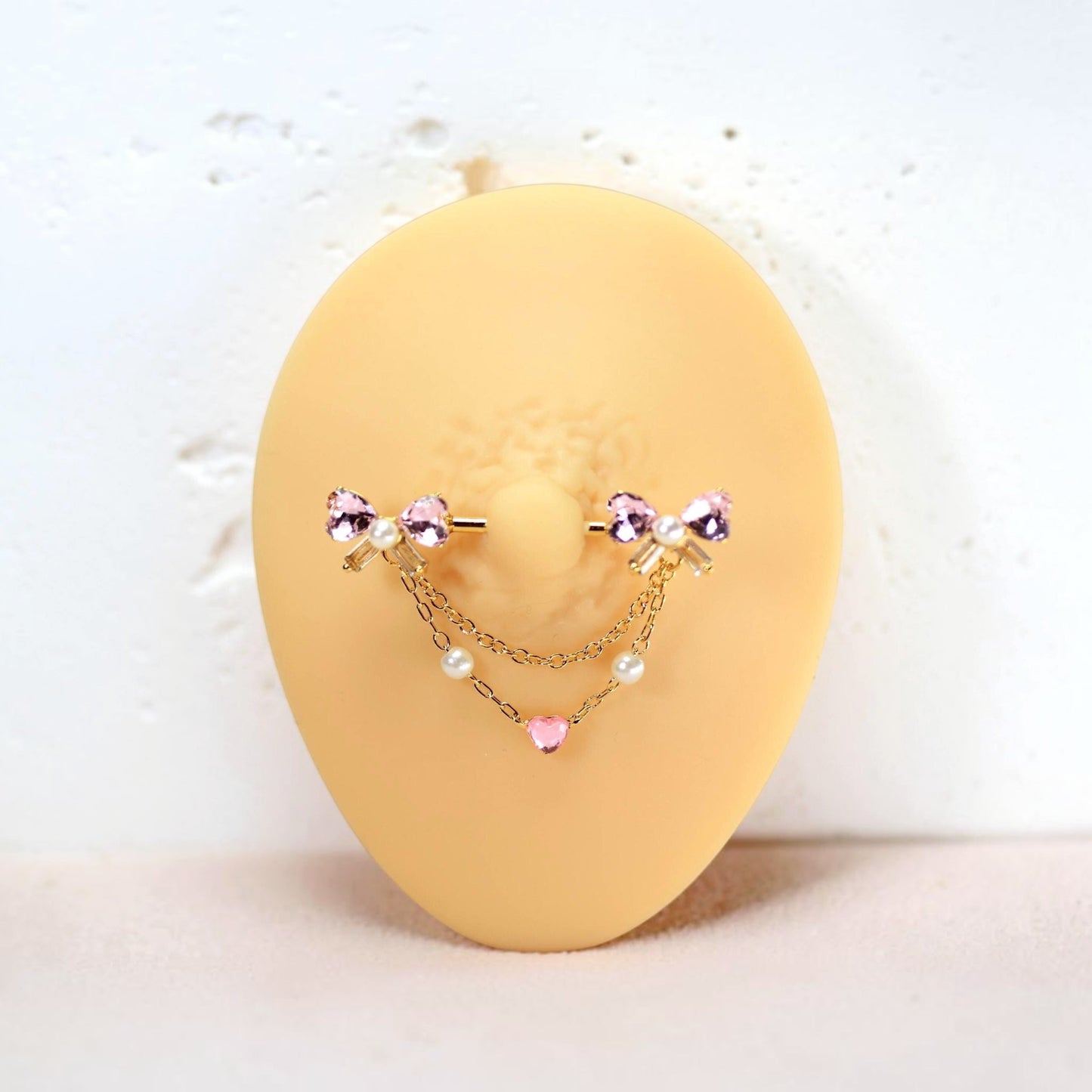 MKBodyJewelry gold 14g nipple barbell with pink bow heart charms, pearls, and surgical steel.