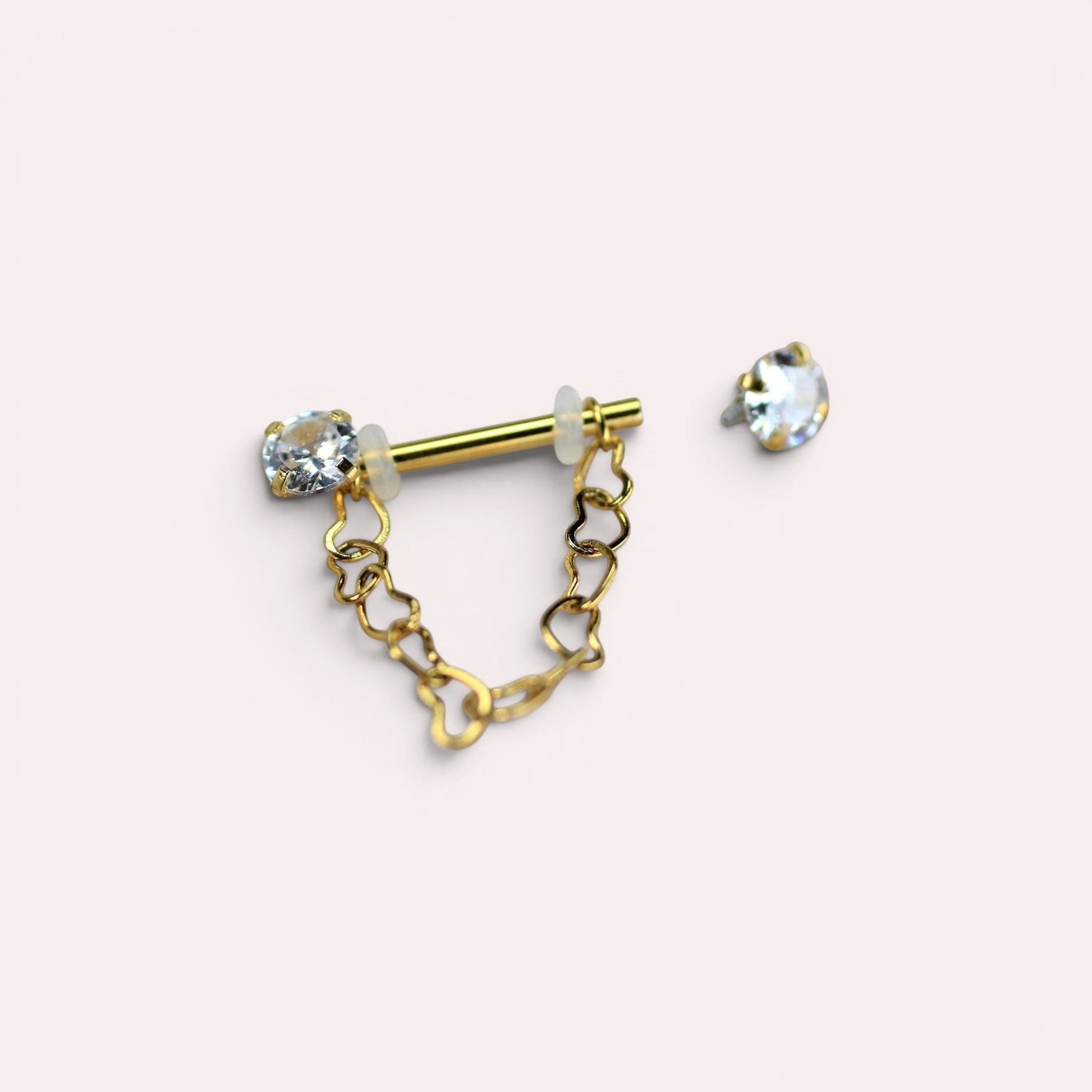MKBodyJewelry gold surgical steel nipple barbell with dangling heart chain and CZ prong end. Sold as a pair.