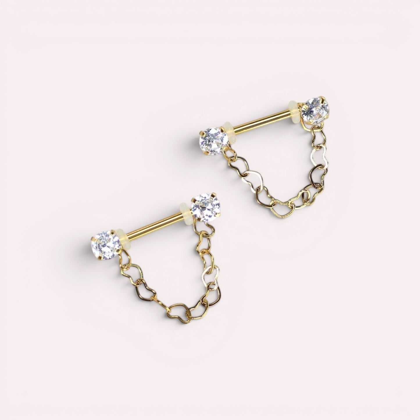 MKBodyJewelry 14g gold surgical steel nipple barbell with dangling heart chain and CZ prong ends. Sold as a pair.