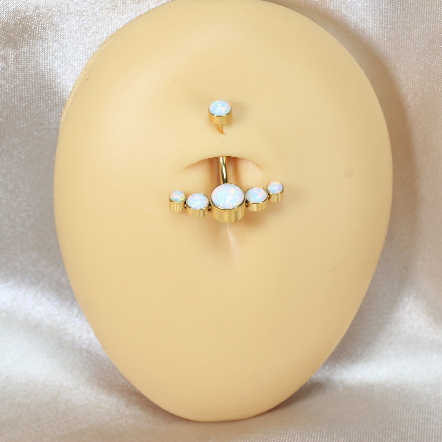 MKBodyJewelry gold titanium floating navel ring with five white opals on a display mannequin