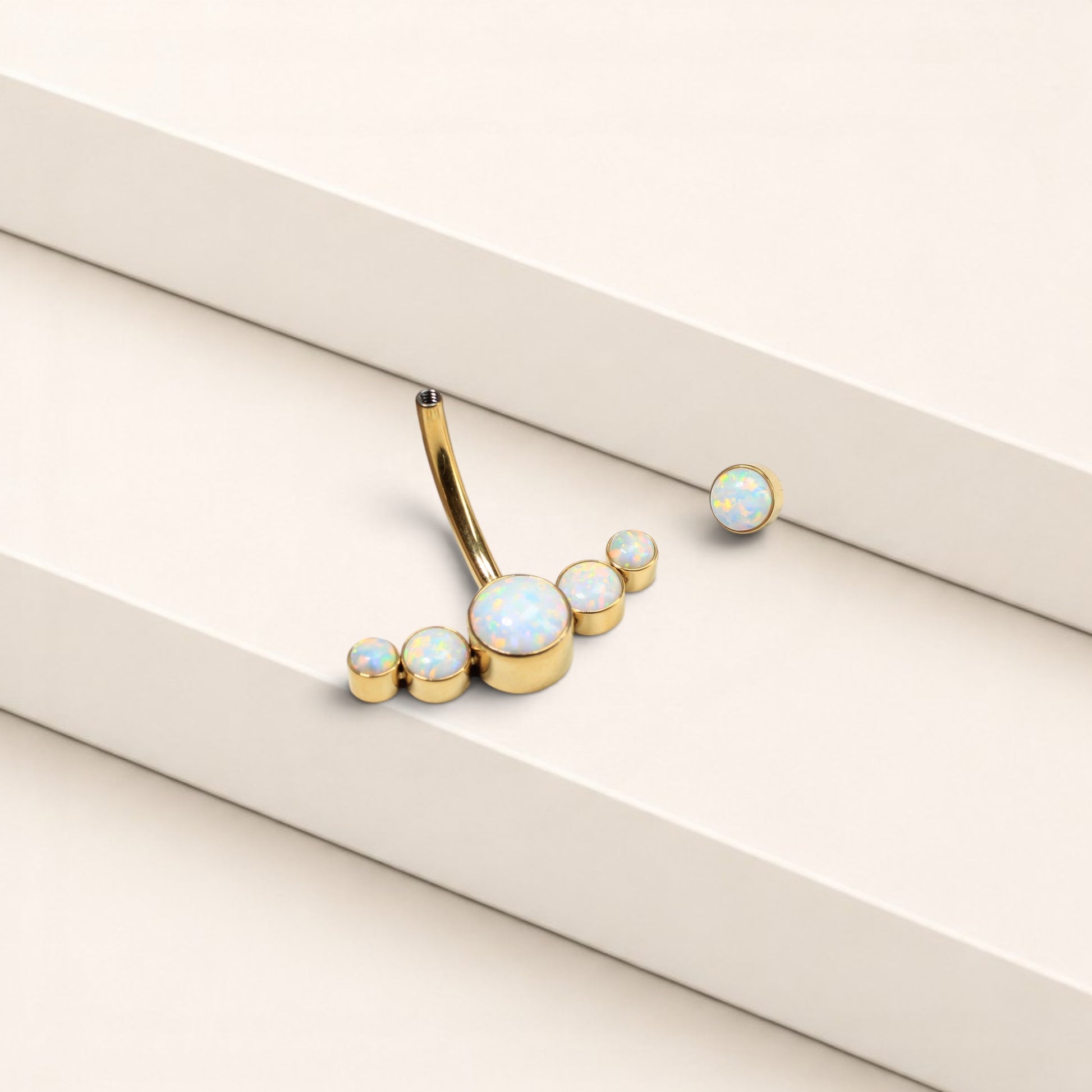 MKBodyJewelry 14G gold titanium floating navel ring featuring a curved barbell with five iridescent opal stones.