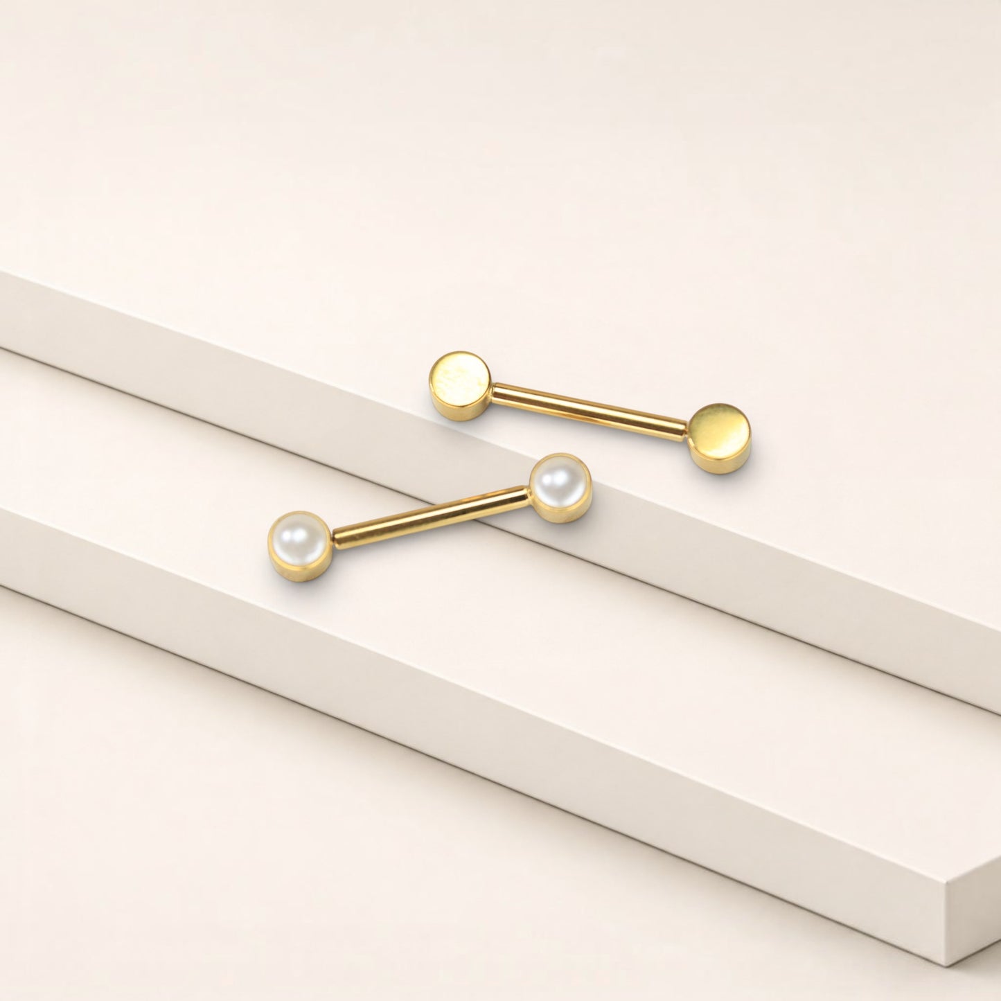 MKBodyJewelry 14g gold titanium threadless nipple barbells with 5mm pearl ends on a minimalist white display.
