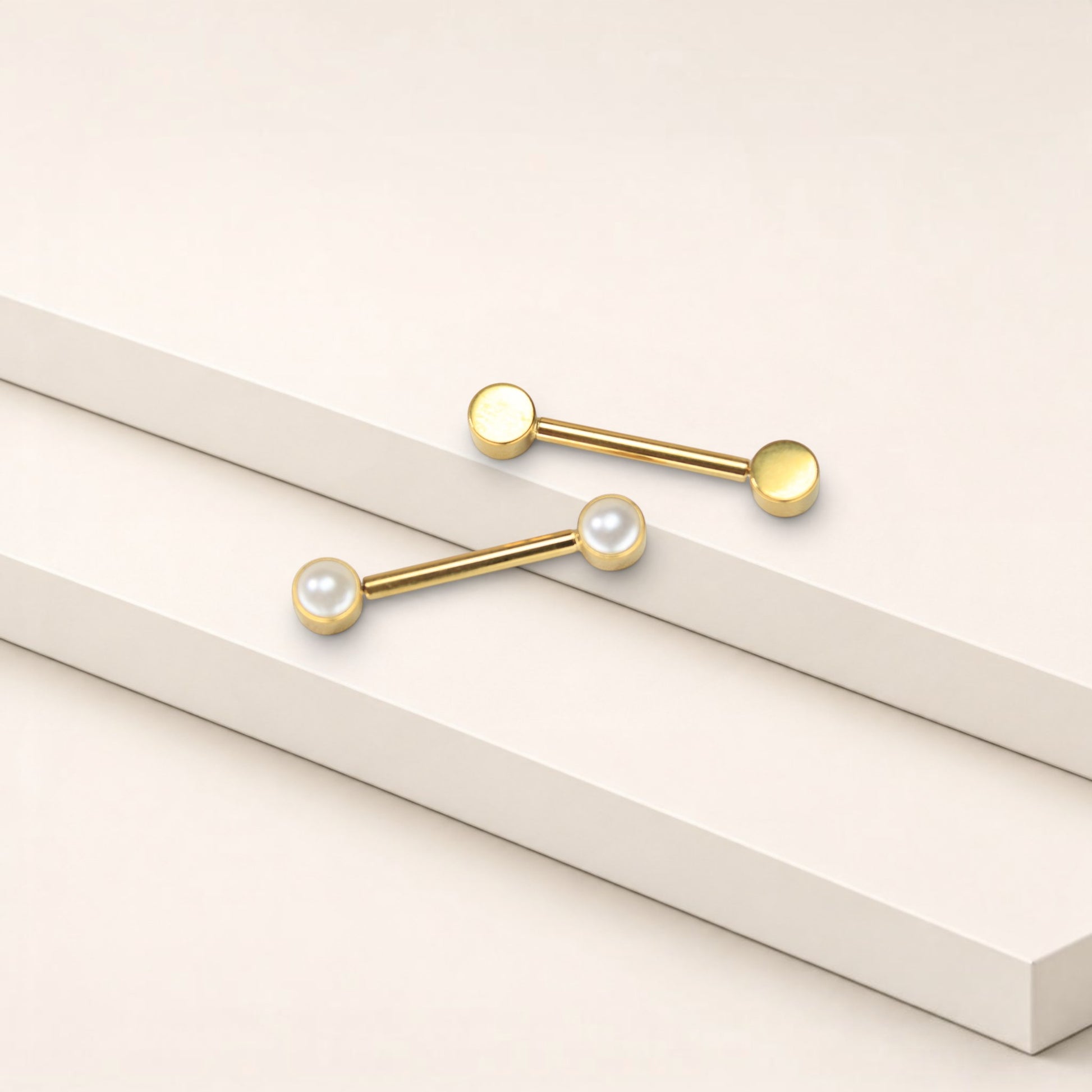 MKBodyJewelry 14g gold titanium threadless nipple barbells with 5mm pearl ends on a minimalist white display.