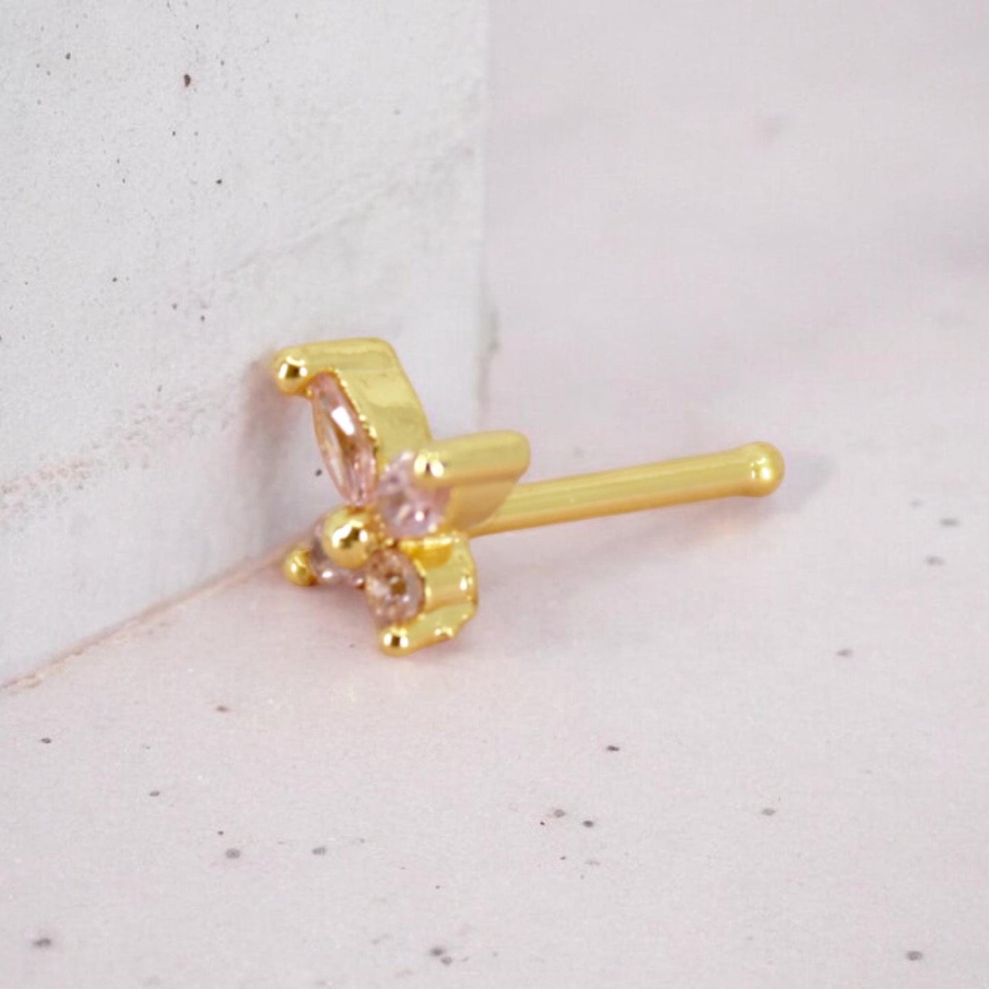 MKBodyJewelry dainty gold nose stud featuring a sparkly pink butterfly gemstone design with a 20g thin post.