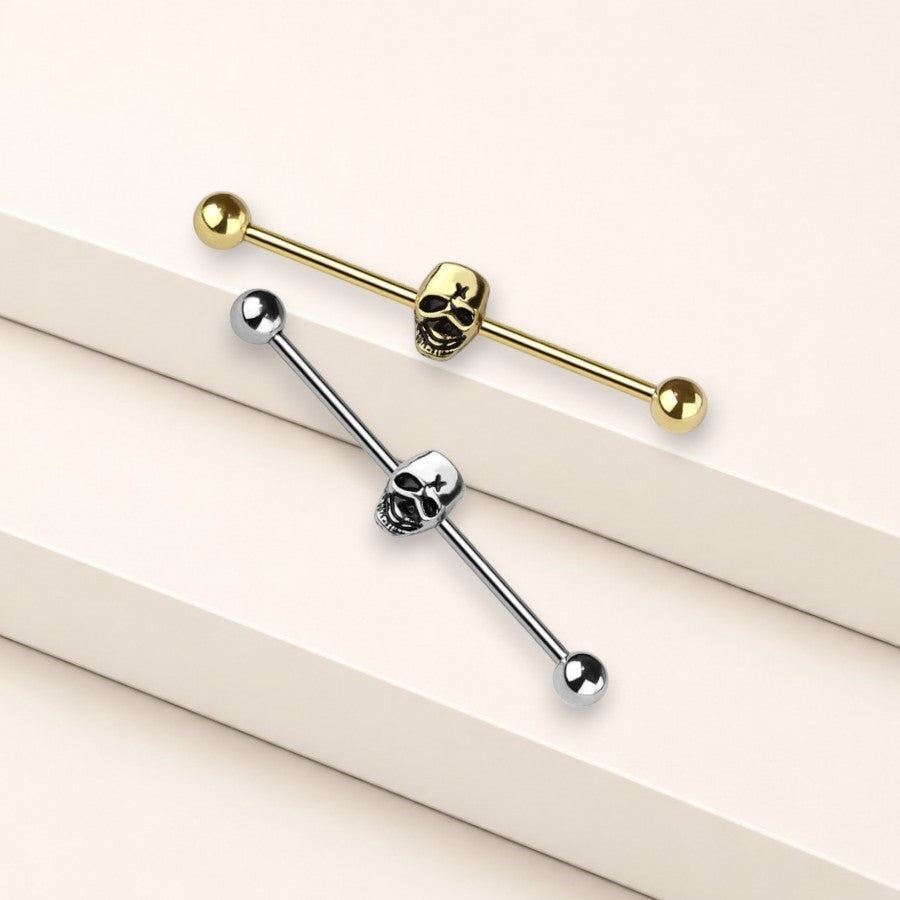 MKBodyJewelry gold industrial barbell featuring a detailed skull charm for cartilage piercings.